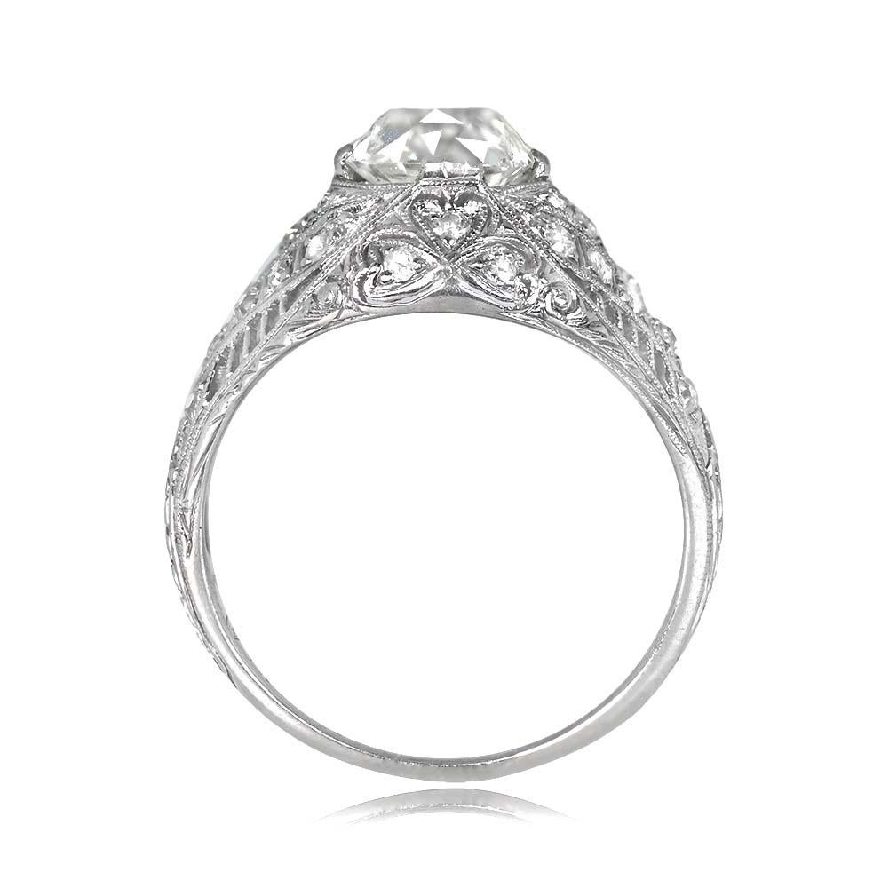 An antique engagement ring showcasing a 1.38-carat old mine-cut diamond in prongs, K color, and VS1 clarity. The dome-shaped platinum mounting is embellished with intricate openwork filigree, delicate milgrain, and hand engravings. Single-cut