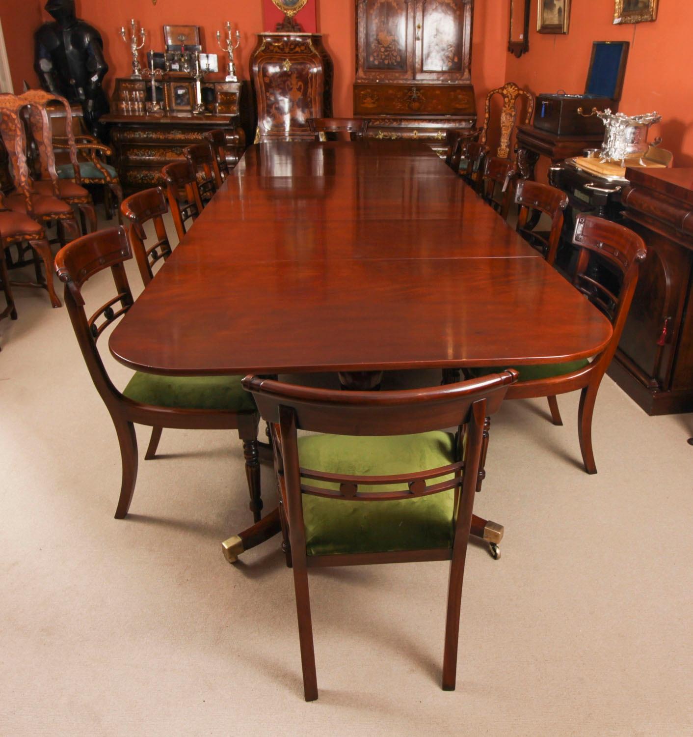 Il s'agit d'un élégant ensemble de salle à manger antique qui comprend une table à trois piliers Regency datant de 1830 et un ensemble de douze chaises de salle à manger à dossier fleuri Regency Revival datant de la fin du 20e siècle.

La table