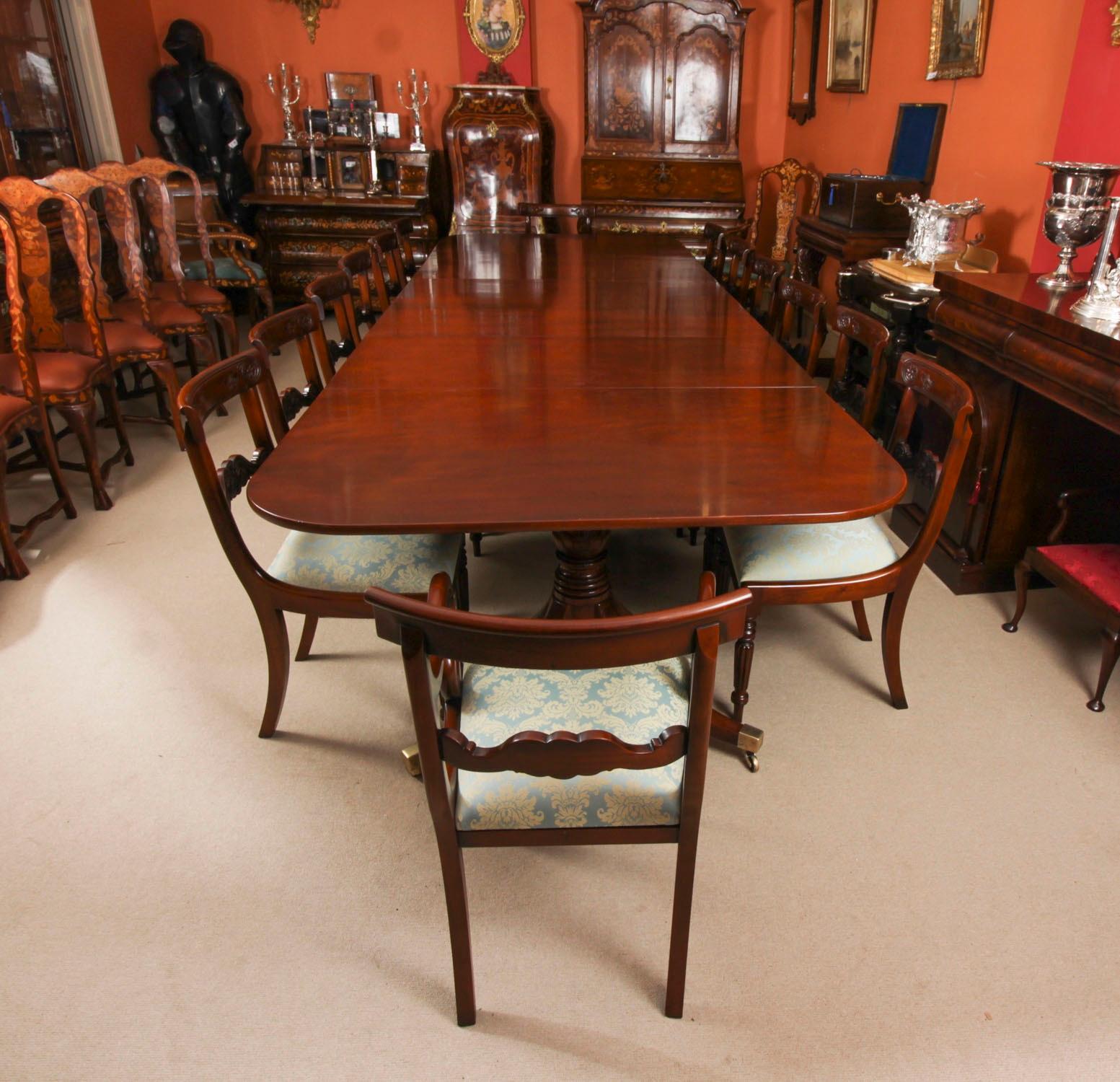 Il s'agit d'un élégant ensemble de salle à manger antique comprenant une table de salle à manger Regency à trois piliers datant de 1830 et un ensemble de quatorze chaises de salle à manger du 20e siècle.

La table possède deux plateaux qui peuvent