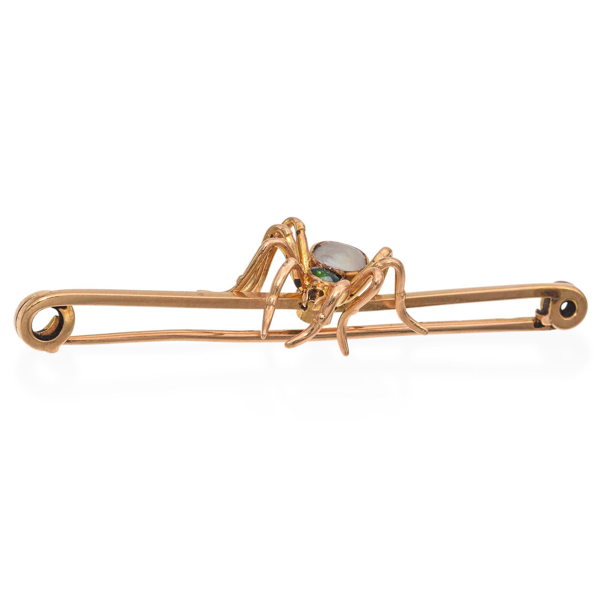 An exquisite brooch featuring a captivating spider design. Crafted in rose gold, this piece showcases a lifelike spider motif with intricate detailing. The body of the spider is adorned with a lustrous white mother of pearl, creating a striking