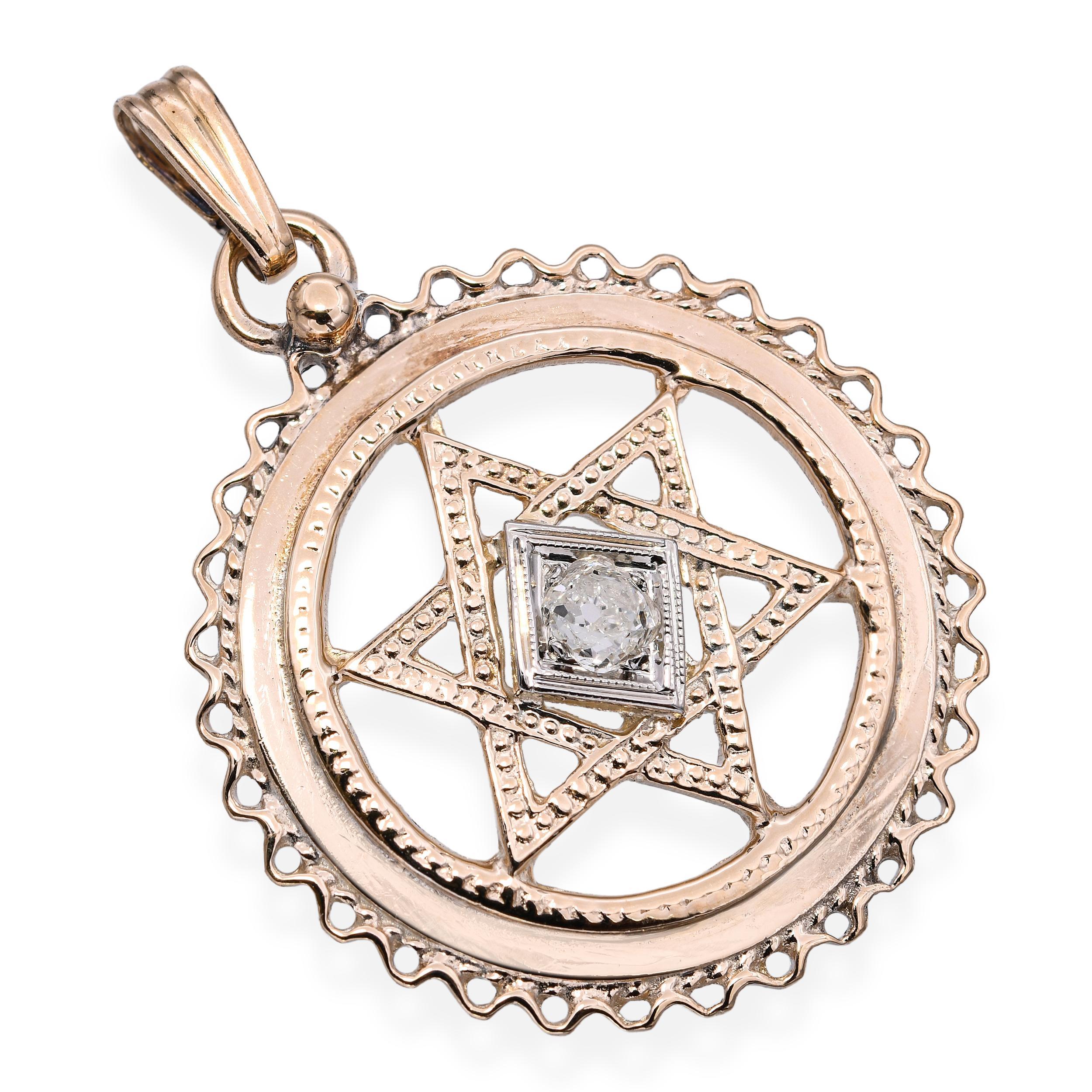 Ce pendentif antique significatif présente une étoile de David magnifiquement travaillée en or jaune 13 carats, centrée sur un diamant étincelant taillé dans une mine ancienne et serti dans une monture en or blanc. L'étoile ajourée est entourée
