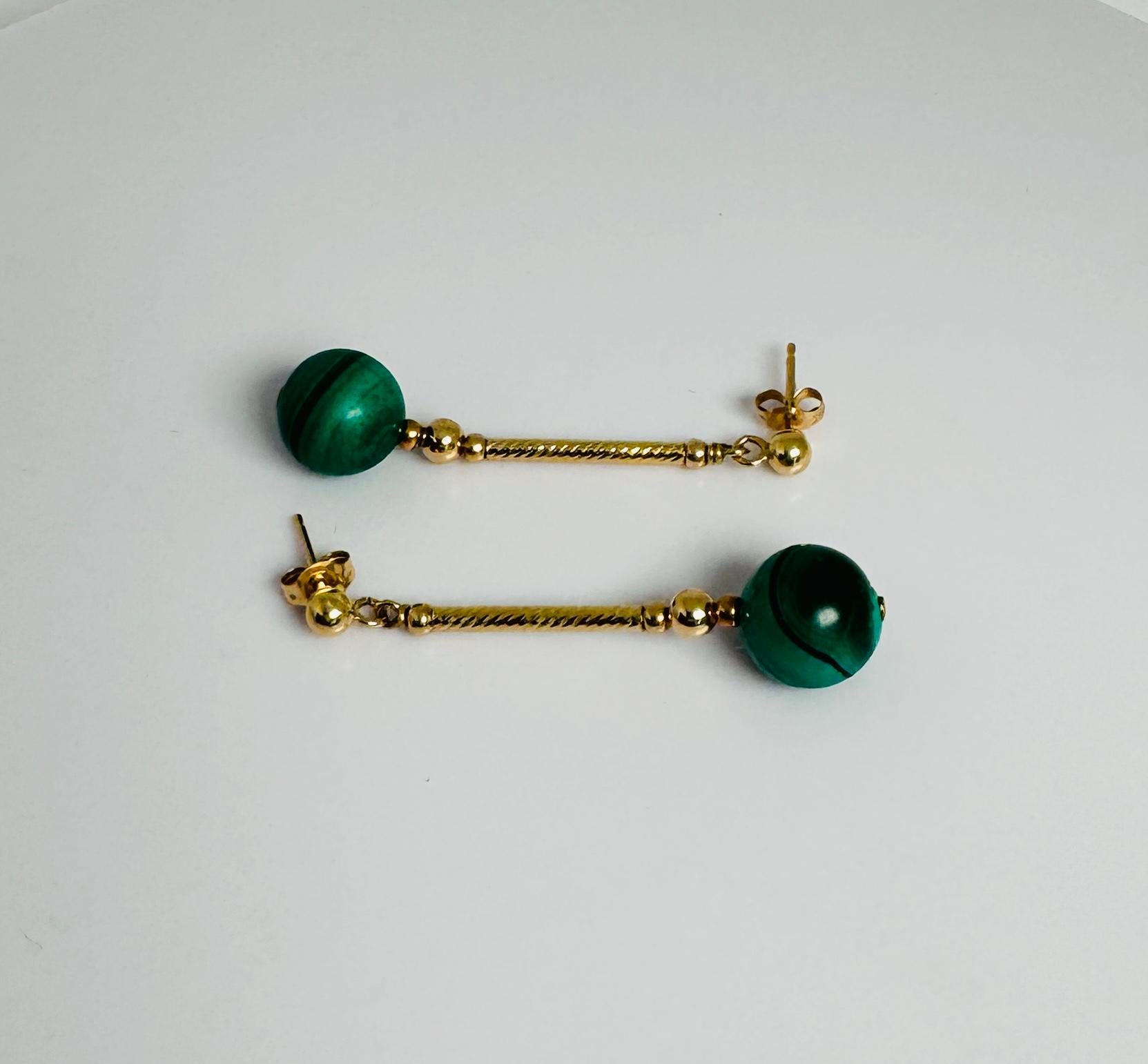 Too cute, 14 carat golden antique earrings with green macalite bols. The hanging part is elegantly twisted and these pre-loved ones are about 2.4 cm long and total weight is about 2.5 grams. Mint condition. This preloved piece of jewelry has an