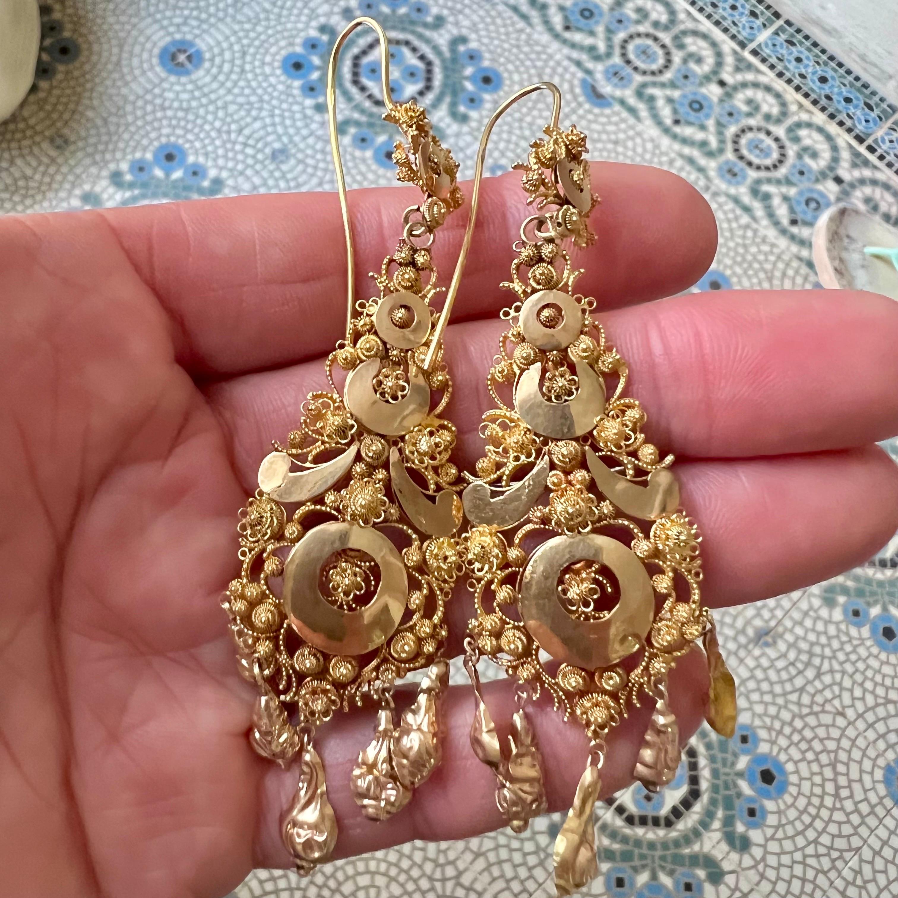 Diese antiken Ohrringe aus 14-karätigem Gold sind ein atemberaubendes Beispiel für filigrane Handwerkskunst und Cannetille, die von den ikonischen Elementen der niederländischen Cadzand-Tracht inspiriert ist. Die Ohrringe sind aus Mutsenbellen, den