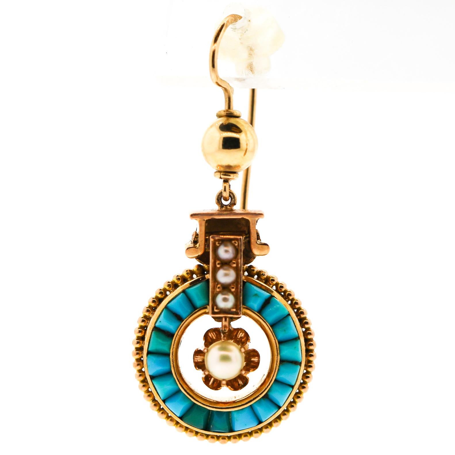 Bright and cheery Victorian 14k gold pendant earrings set with seed pearls, and calibre cut turquoise. The earrings date to about 1880, likely made in the United States. The earrings are hung on hoops that go through the ear, hanging from a hollow