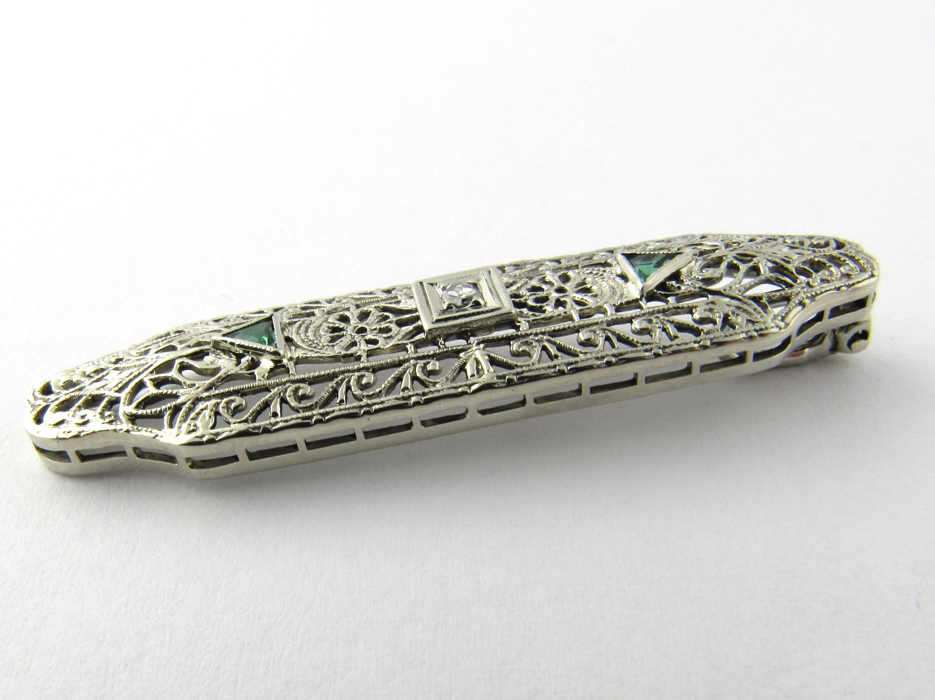 Antique 14 Karat White Gold Diamond and Emerald Pendant- 
This lovely pendant features two trillion cut emeralds and one round single cut diamond set in beautifully detailed white gold filigree. 
Approximate total diamond weight: .03 ct. 
Diamond
