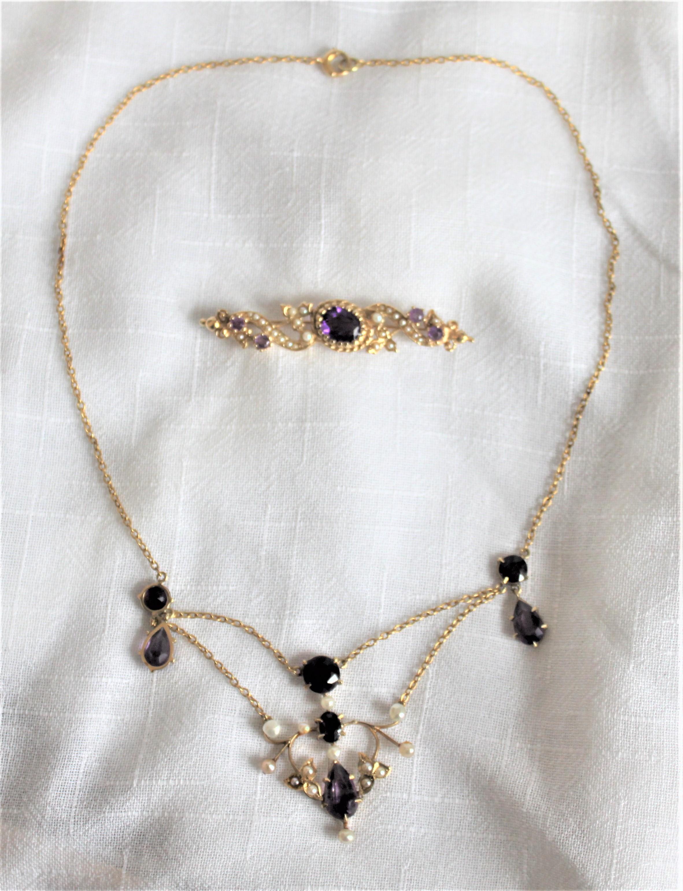 This antique pairing of a yellow 14-karat gold necklace and brooch are presumed to have been made in the United States in circa 1910 in the period Edwardian style. Both pieces are composed of 14-karat yellow gold, amethyst prong set stones and