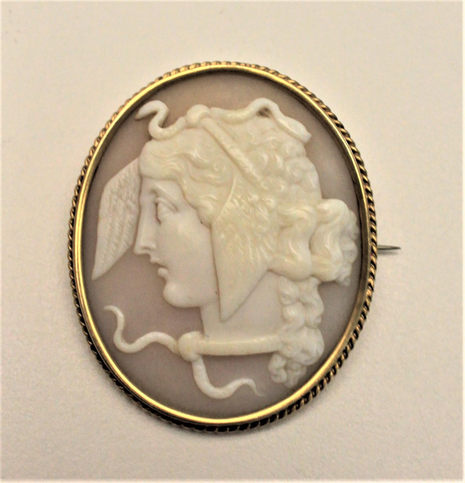 This large antique cameo brooch is presumed to have been made in Italy in approximately the Victorian period in the Greek Revival style. The beaded bezel of the brooch is unmarked, but tests to 14-karat. The hand carved shell depicts a Greek