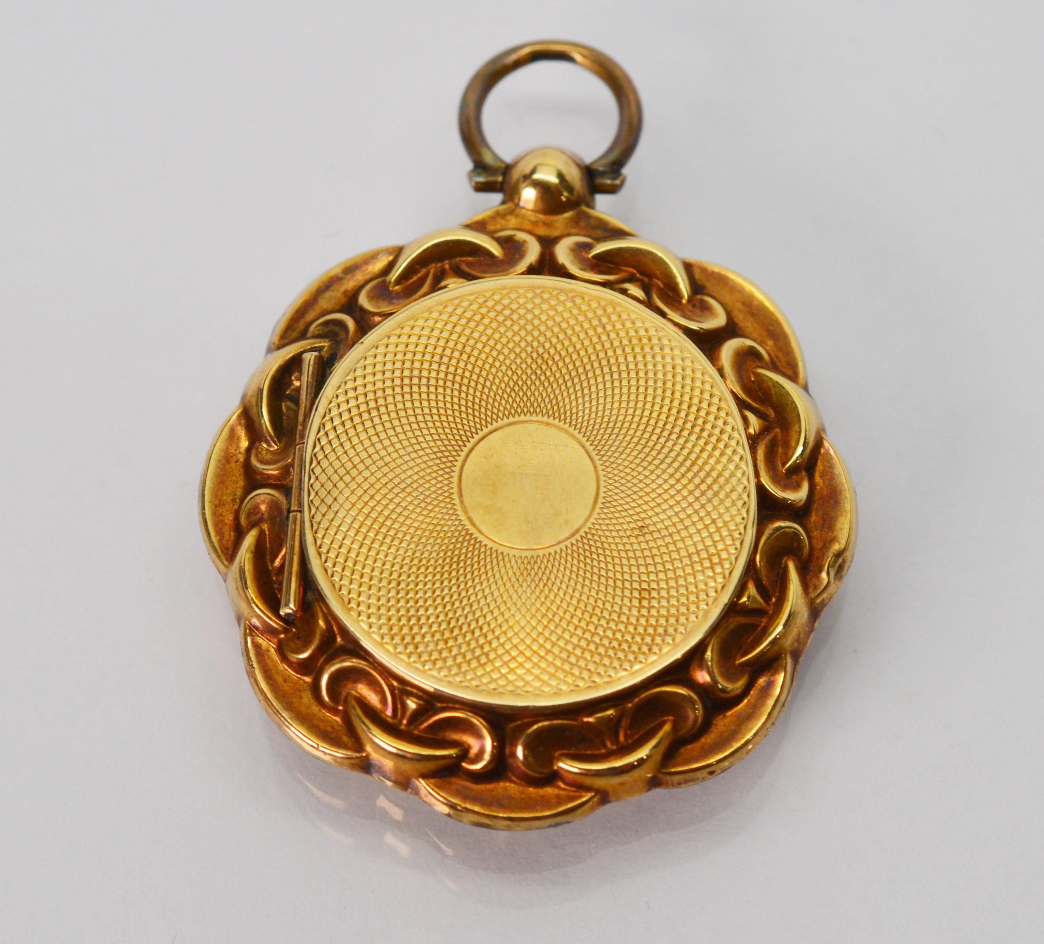 Carry a keepsake close to your heart with this romantic antique twelve karat 12k yellow gold locket charm pendant, lovely to add as an enhancement to your jewelry wardrobe. This circa late 19th century estate piece is designed with flowing fluted