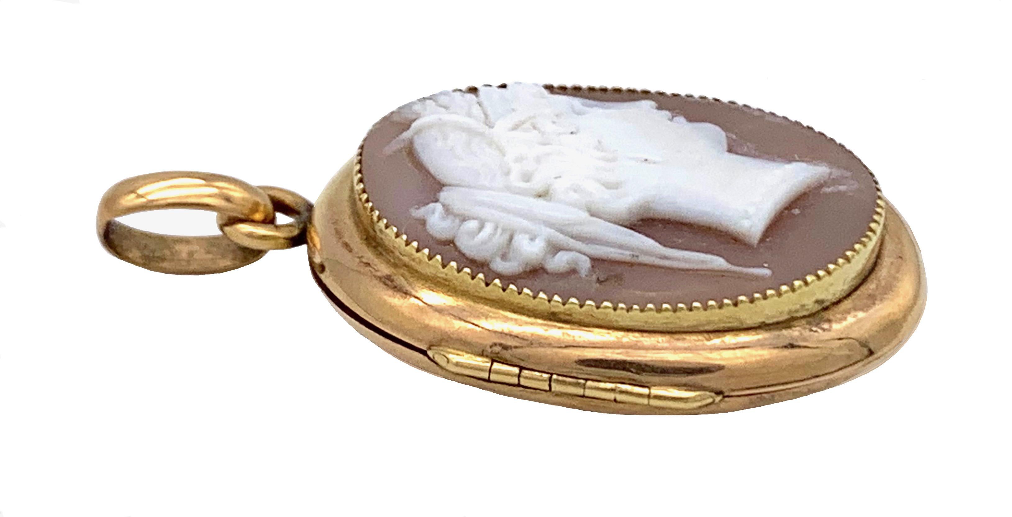 This elegant locket is set with a finely carved oval shell cameo of the profile of a young woman in the antique manner. The cameo has been mounted in a locket made out of 14 karat Gold.