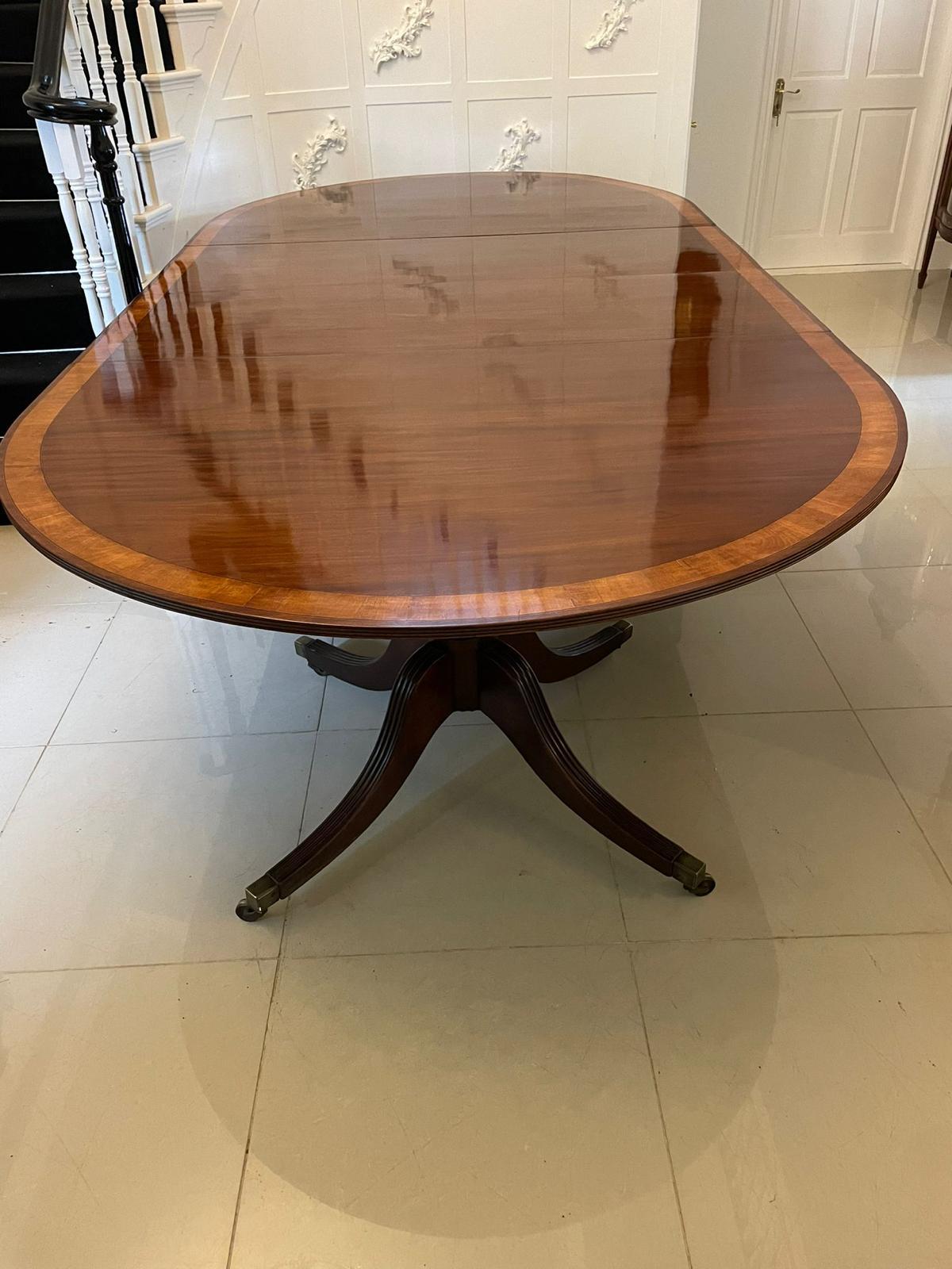 Antique 14 seater George III outstanding quality figured mahogany 3 pilar dining table having an outstanding quality figured mahogany top crossbanded in satinwood and a reeded edge supported by elegant turned pedestal columns standing on four