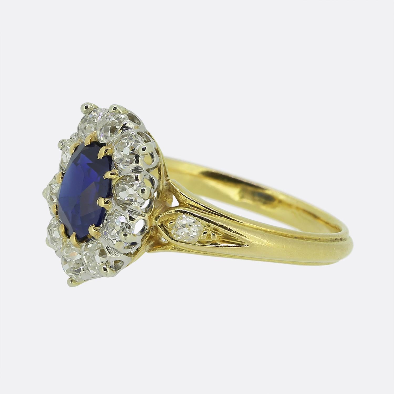 Aquí tenemos un llamativo anillo en racimo de finales del siglo XIX. Esta exquisita pieza exhibe un zafiro azul intenso en su centro, rodeado por un marco de diamantes redondos facetados de talla de mina antigua. El rico color del zafiro queda