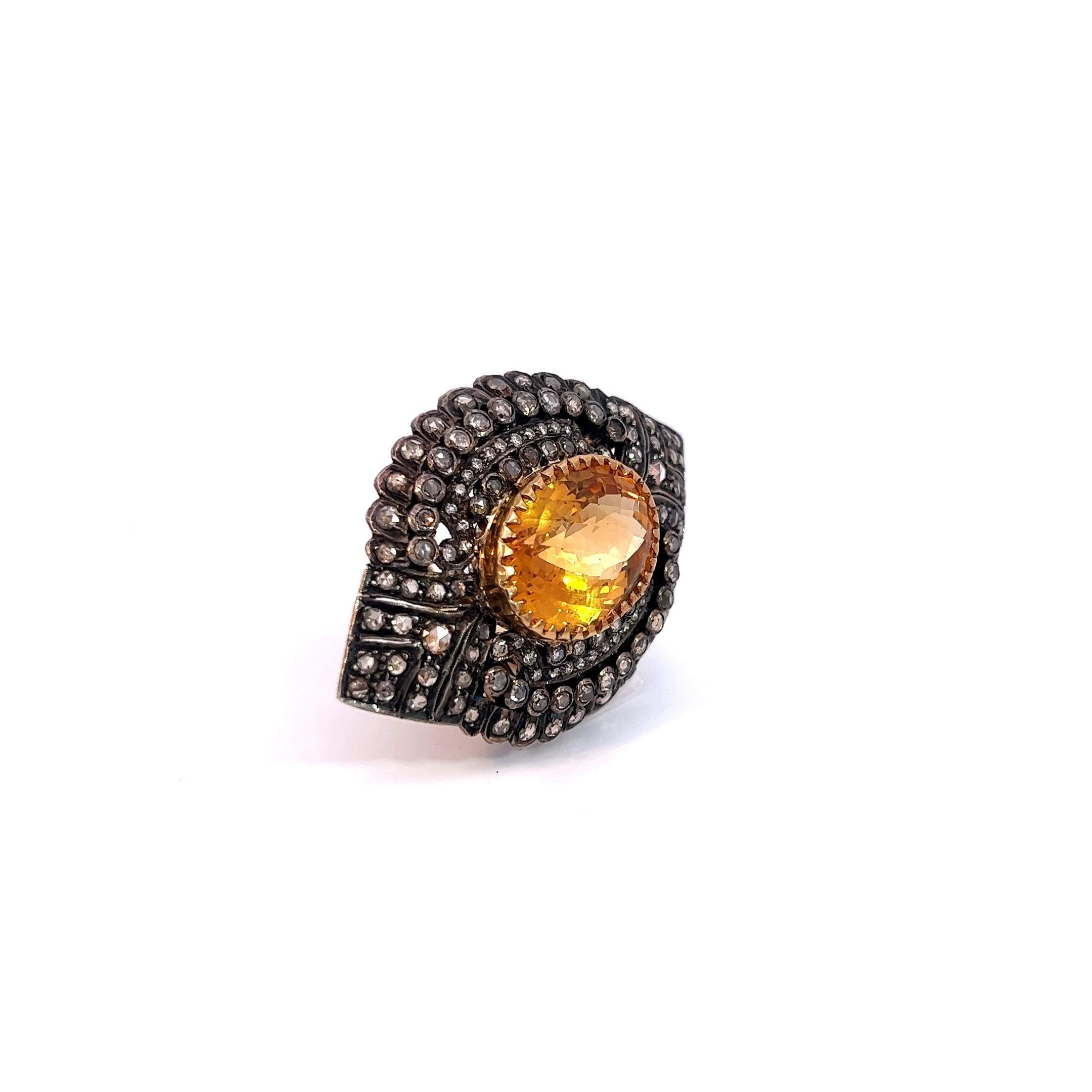 Cette bague est une pièce captivante qui attire l'attention par son design audacieux et ses pierres précieuses exquises. En son cœur, un saphir jaune ovale de 14,5 carats rayonne d'une teinte jaune vibrante. Le saphir est taillé de manière experte