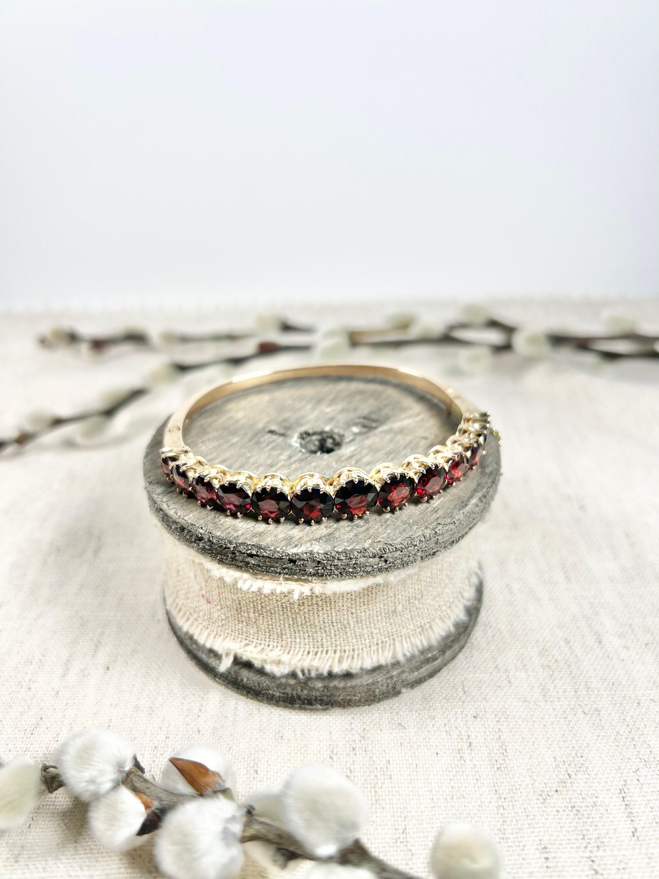 Antique Garnet Bangle 

14ct Gold 

Circa 1900

Fabulous, Edwardian bangle. Set with gorgeous, round, faceted garnet stones. The gems graduate in size from 8-6mm. The shoulders of the bangle have lovely hand carved detailing. The bangle features an