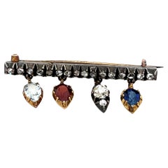Spilla antica in oro e argento 14ct, con zaffiro, granato, acquamarina e diamante incastonati