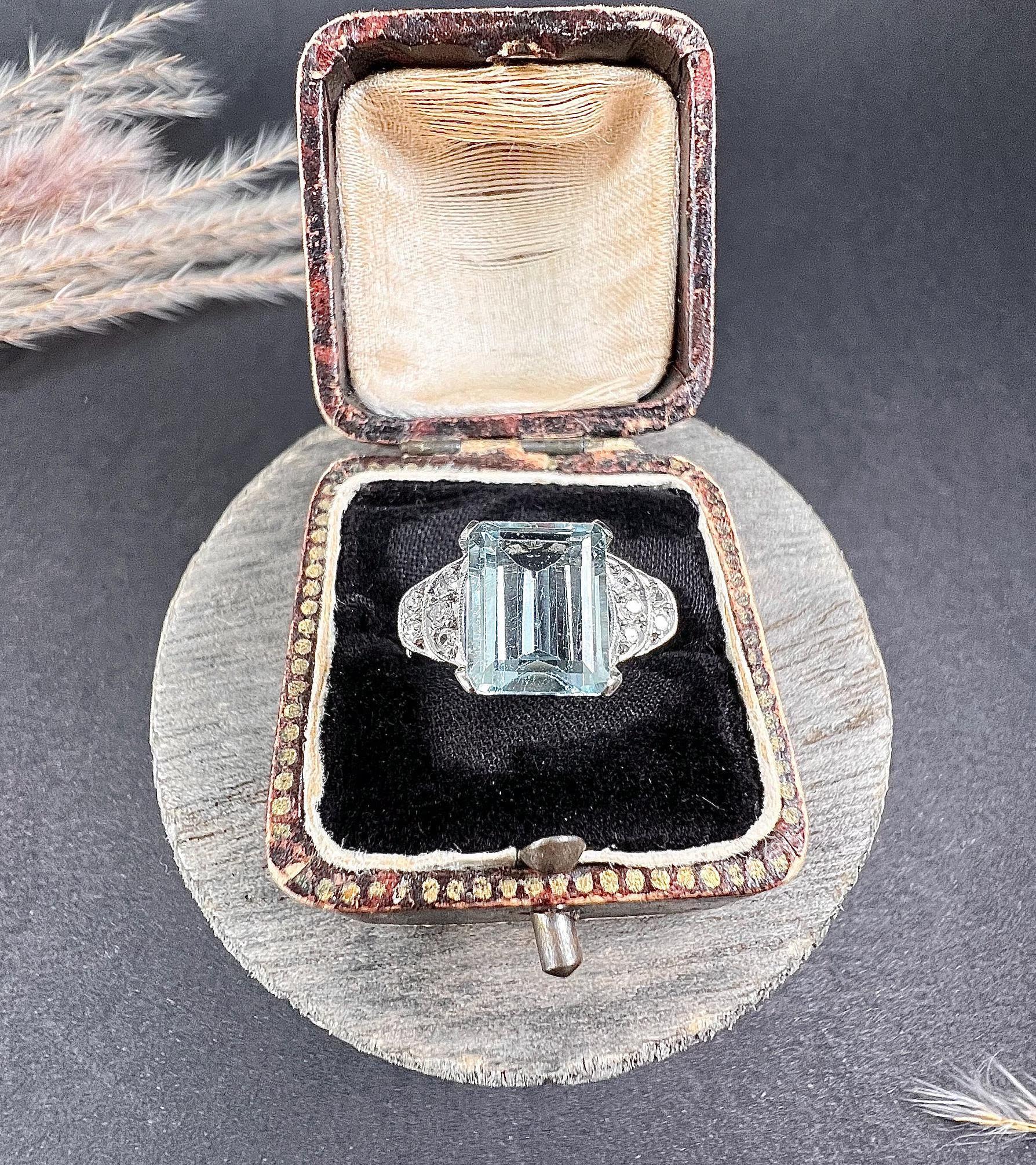 Antique Aquamarine Ring 

14ct White Gold Tested 

Circa 1920s

This fabulous antique piece from the 1920s features a stunning emerald-cut aquamarine elegantly placed between milgraine-set diamond shoulders. The 14ct white gold setting enhances the