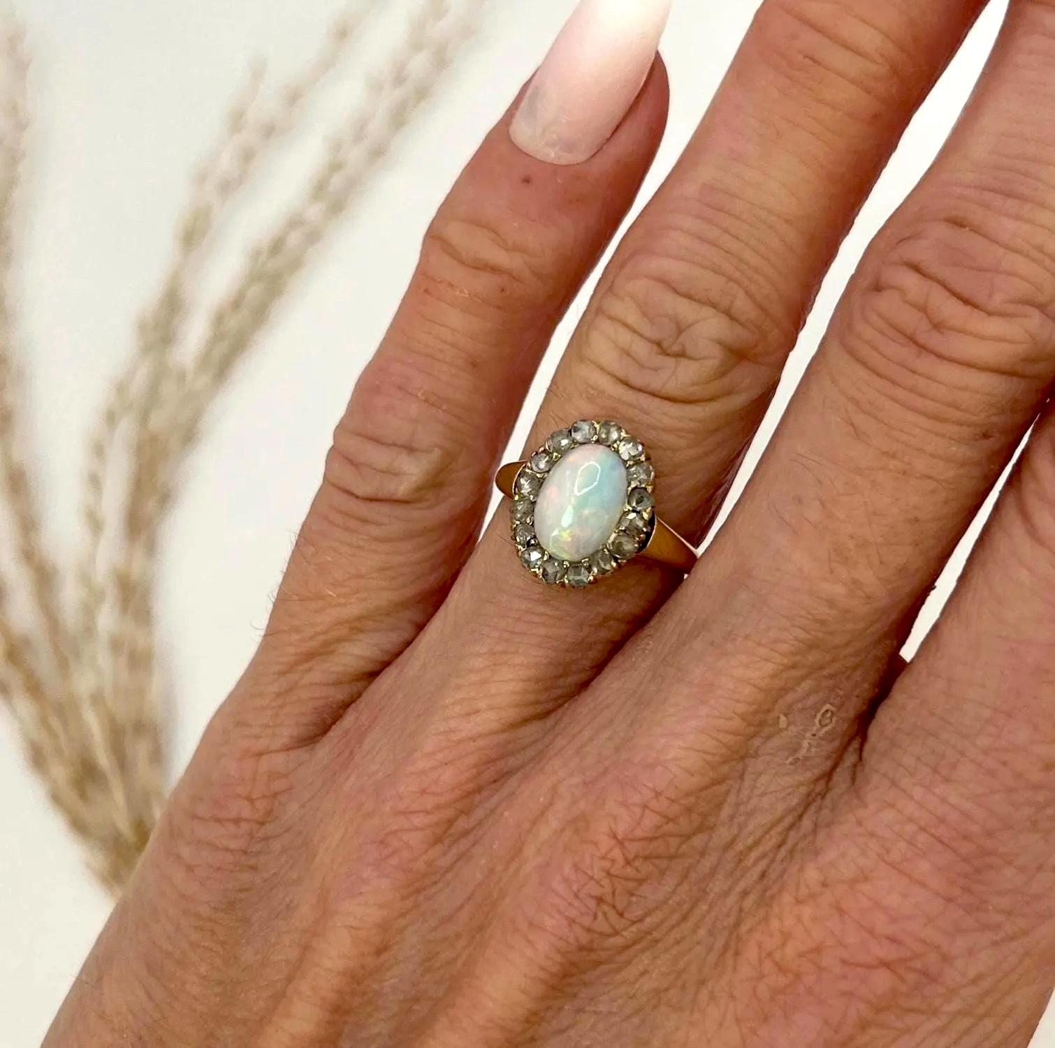 Antiker Opal & Diamant Oval Cluster Ring 

14ct Gold gestempelt

CIRCA 1910

Wir präsentieren einen atemberaubenden edwardianischen Ring aus 14 Karat Gold mit einem ovalen Opal in der Mitte, umgeben von sechzehn Diamanten im Rosenschliff. 

Die