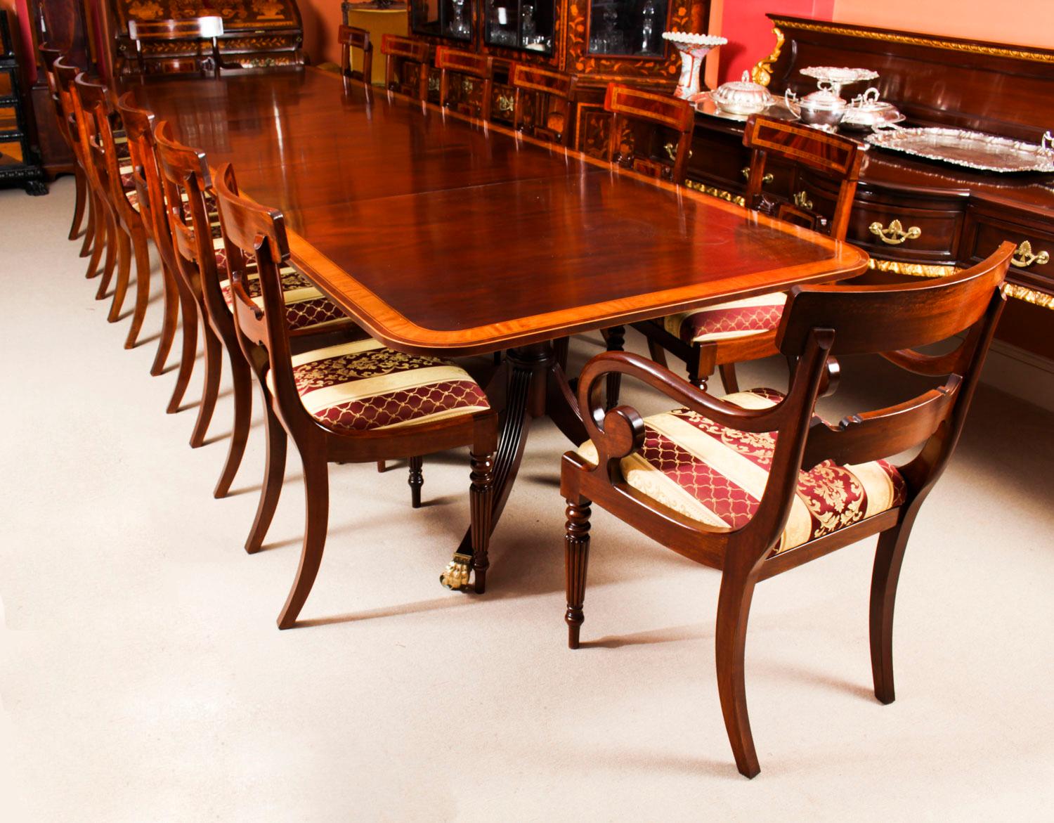 This is a superb antique 14ft Regency Revival dining table, crafted in flame mahogany and featuring superb satinwood crossbanded decoration, and dating from the late 19th century.

Capable of seating fourteen people in Regal comfort it is an