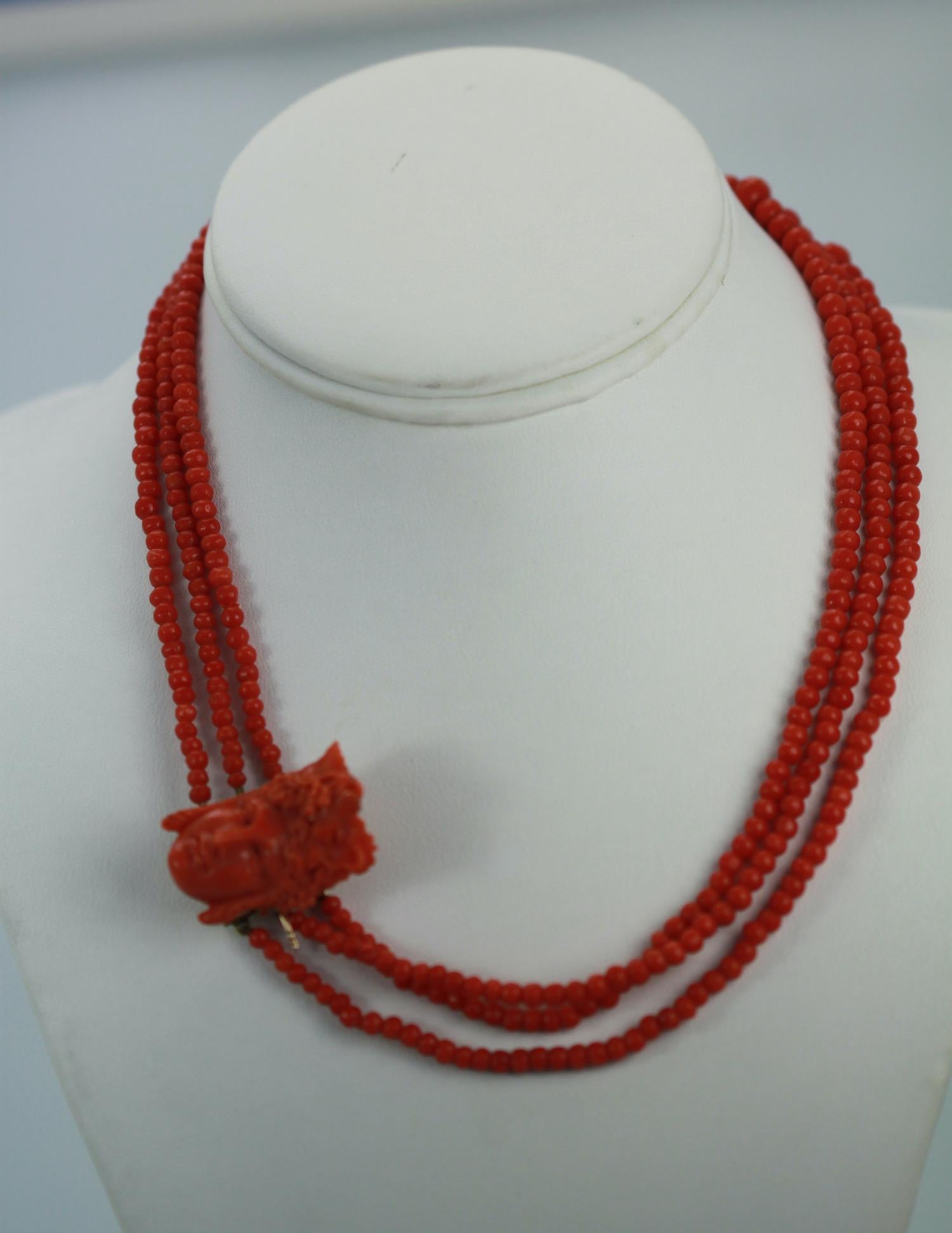 This lovely coral triple strand necklace has a carved Coral face of Bacchus.  The head is 1 1/4