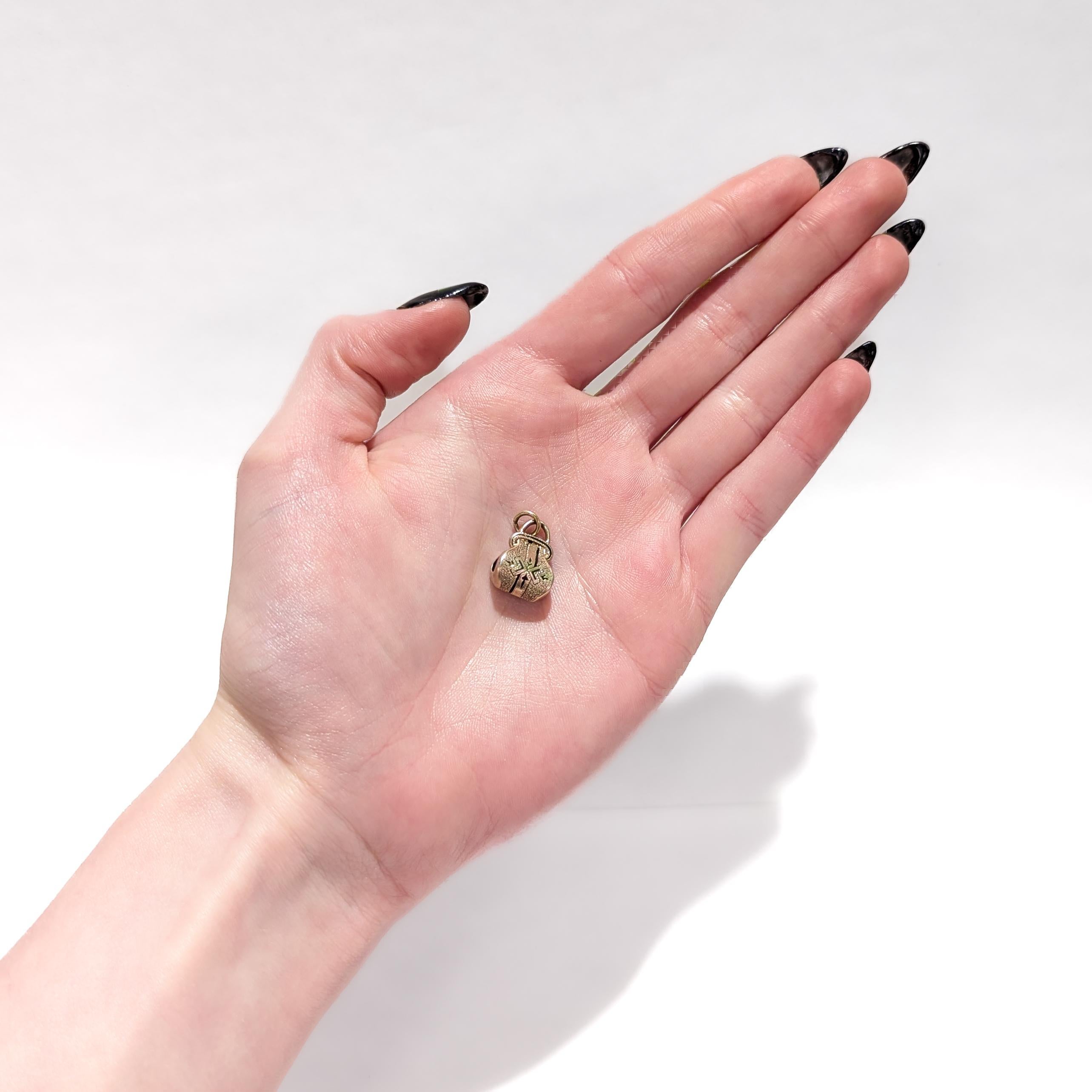 Un raffinato charm in oro antico e smalto per un bracciale a scorrimento.

In oro giallo 14 carati.

Con accenti di smalto nero.

Con un anello di collegamento al manico della borsa.

Un gioiello semplicemente meraviglioso!

(La catena è solo a