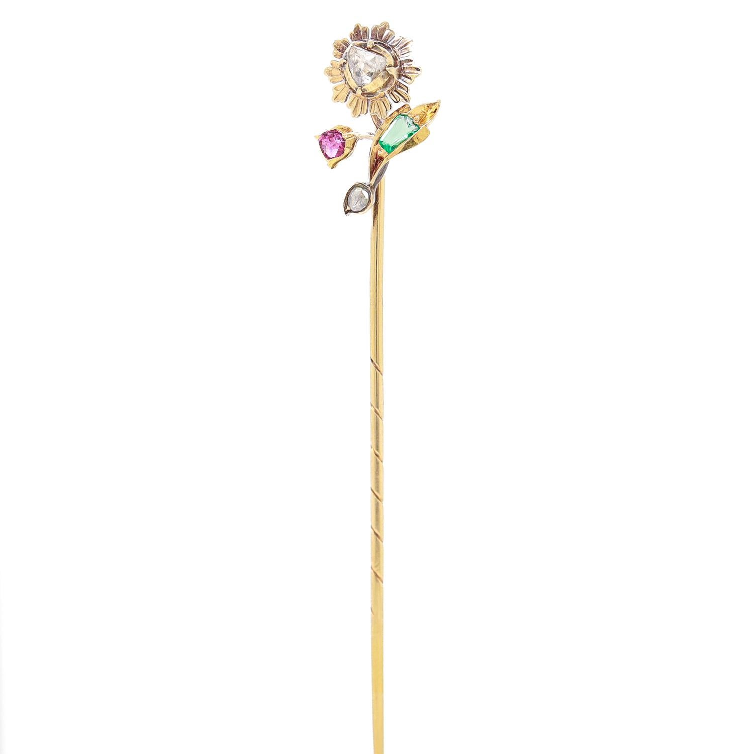 Une épingle à nourrice en or fin et pierres précieuses.

Sous la forme d'une fleur stylisée avec des feuilles et de multiples boutons floraux.

En or 14 carats.

Serti à l'emporte-pièce de plusieurs pierres précieuses, dont deux diamants taillés en