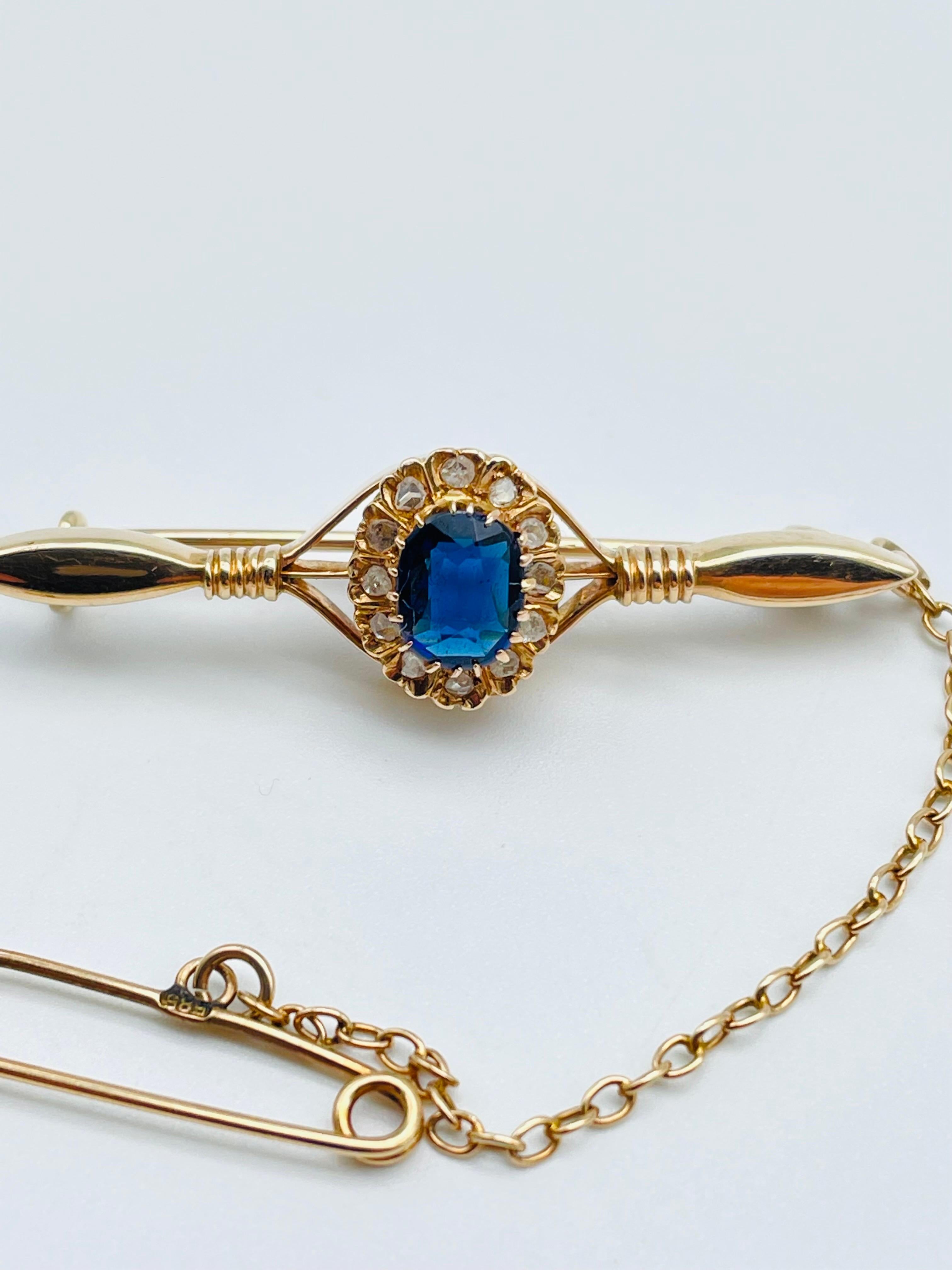 This antique 14k gold bar brooch is an exquisite piece of jewelry that exudes elegance and charm. The rose gold setting is finely crafted, with every detail meticulously executed. The centerpiece of the brooch is a polished tanzanite, with a