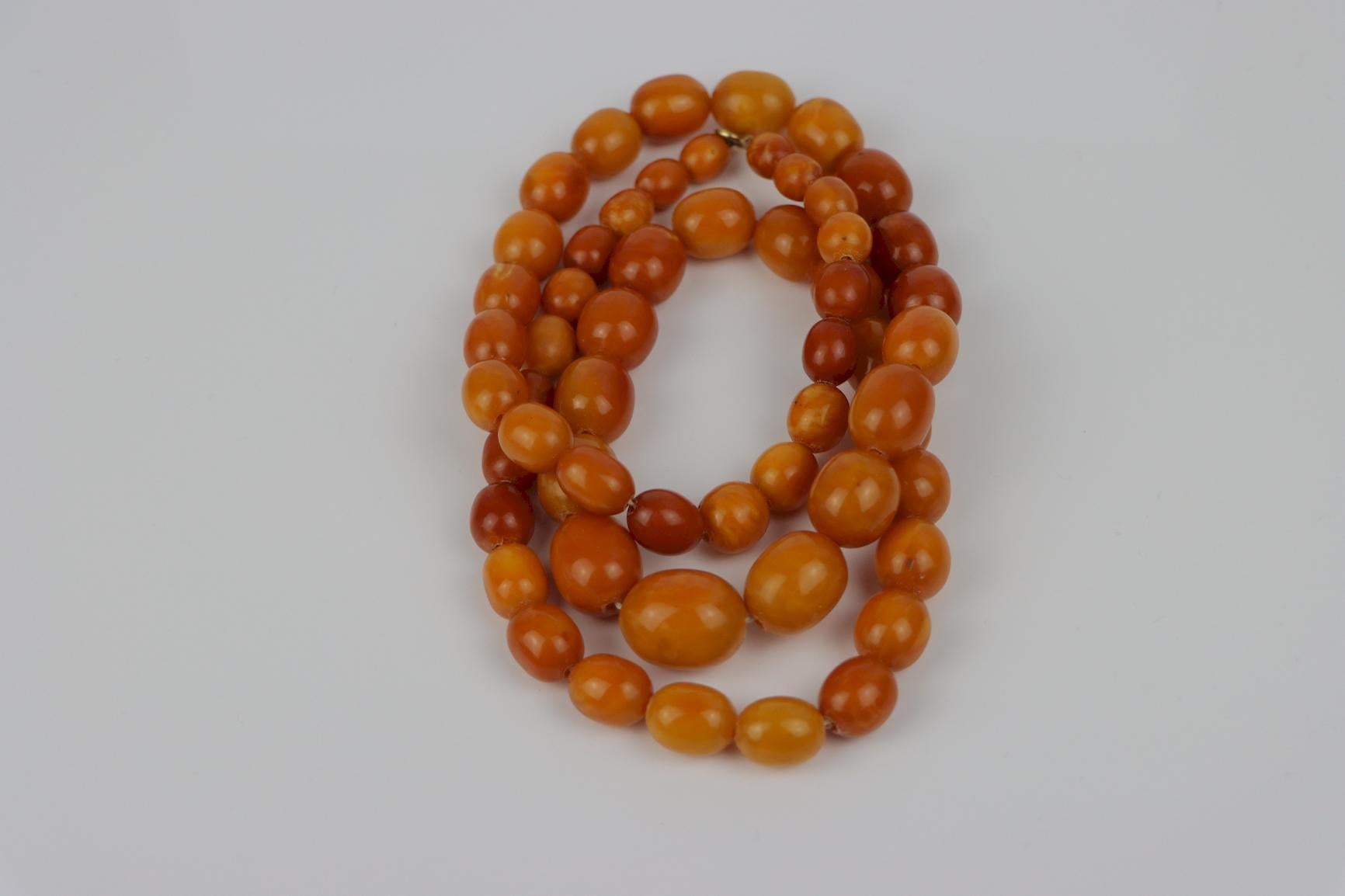 Antique 14K Gold Beeswax Amber Bead Necklace
 
Antique Strand of Graduating Beeswax Amber beads with a 14K Gold clasp.
Circa:
1920

Approximate Dimensions:
41.28 cm (Clasped/Doubled Length) x 83.8 cm (Unclasped Length)
21.25 x 17.10 mm 
10.7 x 8.88
