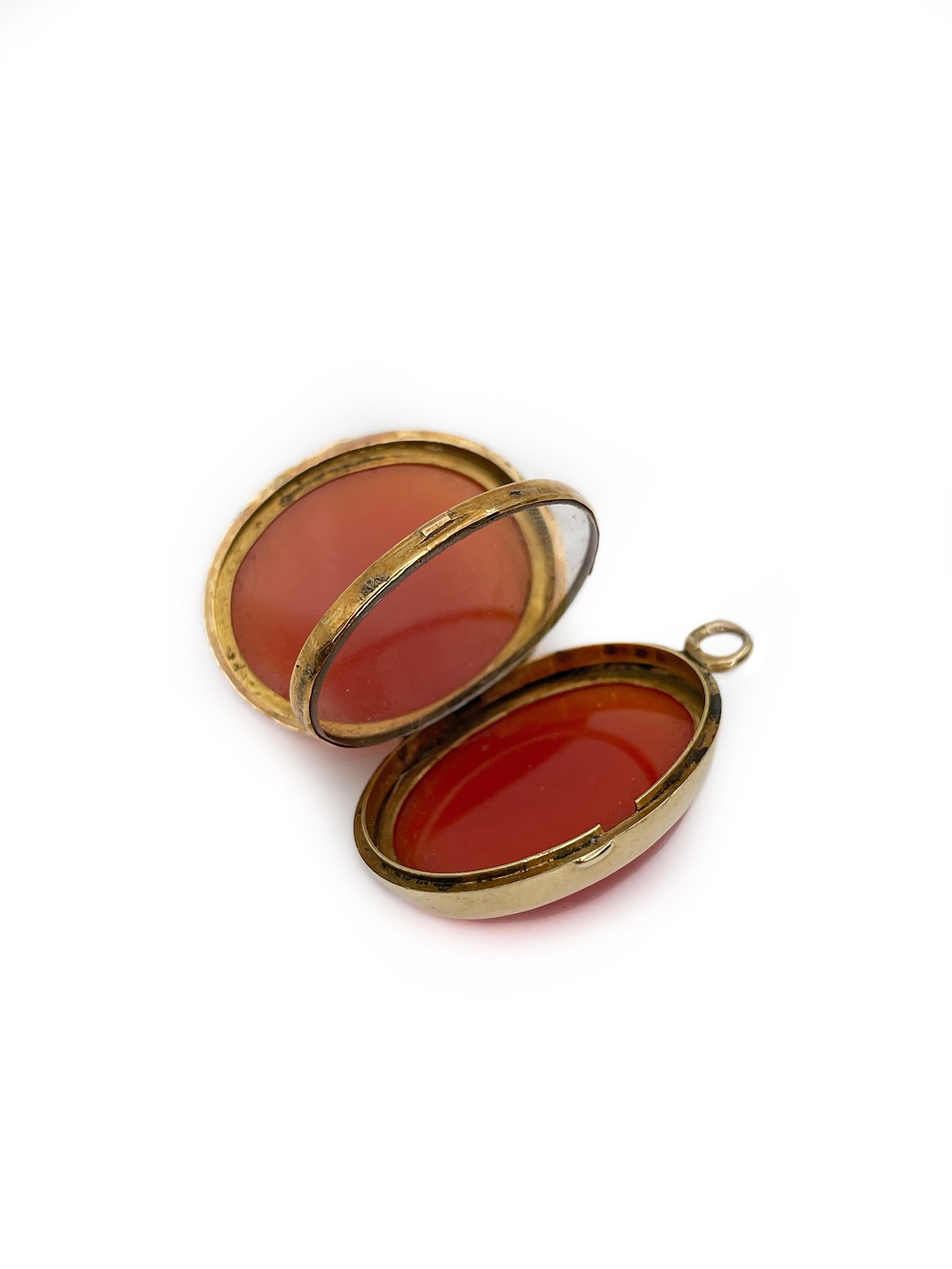 This is a unique antique locket crafted in 14K gold. The piece is made of two cabochon cut carnelians. It has a glass frame and space for pictures inside. 

Weight: 10.38g
Length: ~3cm
Width: ~1.8cm