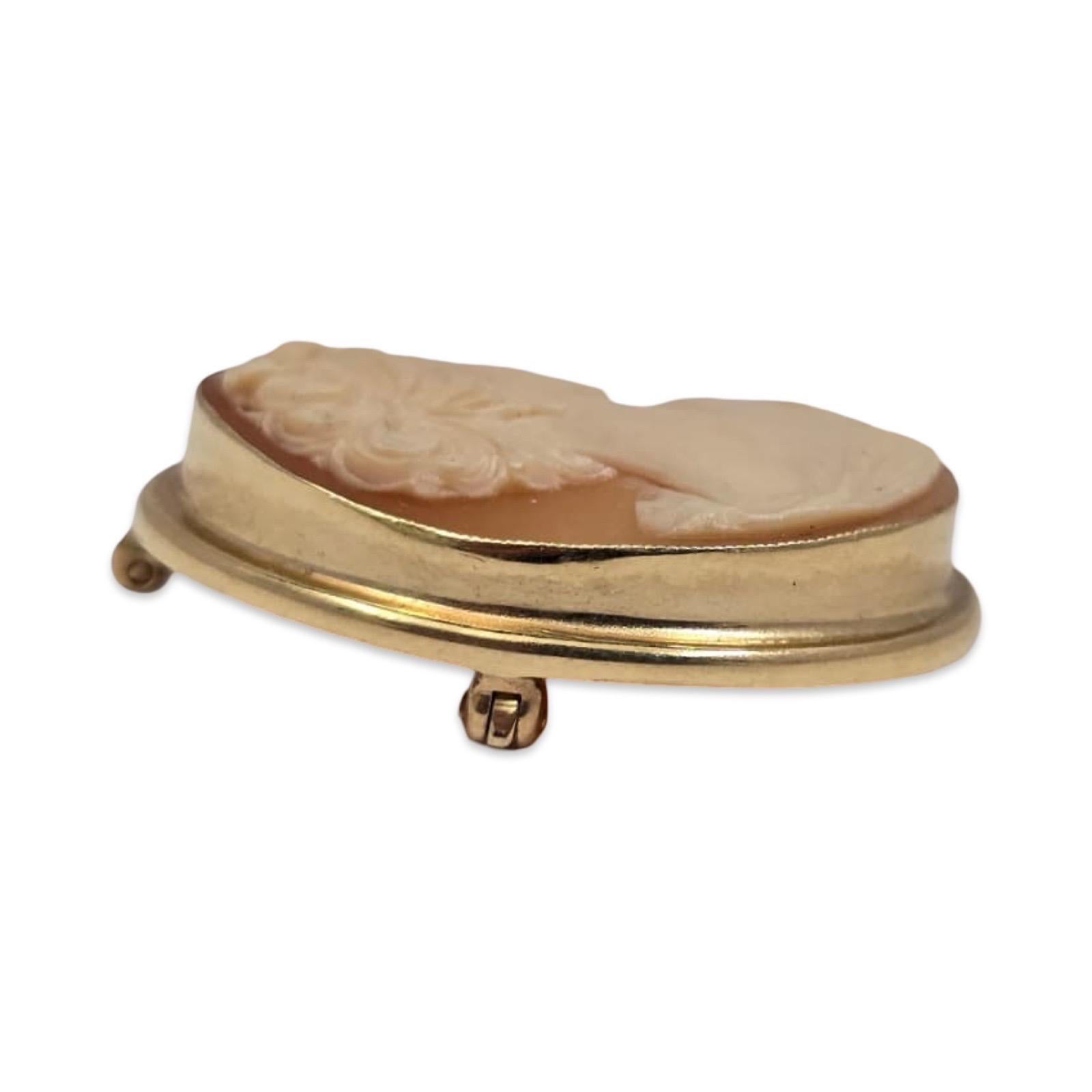 Antiguo camafeo de concha tallado a mano en oro macizo de 14 quilates, que representa un perfil femenino clásico con elegante esculpido y suaves detalles. Engarzada en un bisel de oro pulido con un accesorio convertible en broche-colgante y una