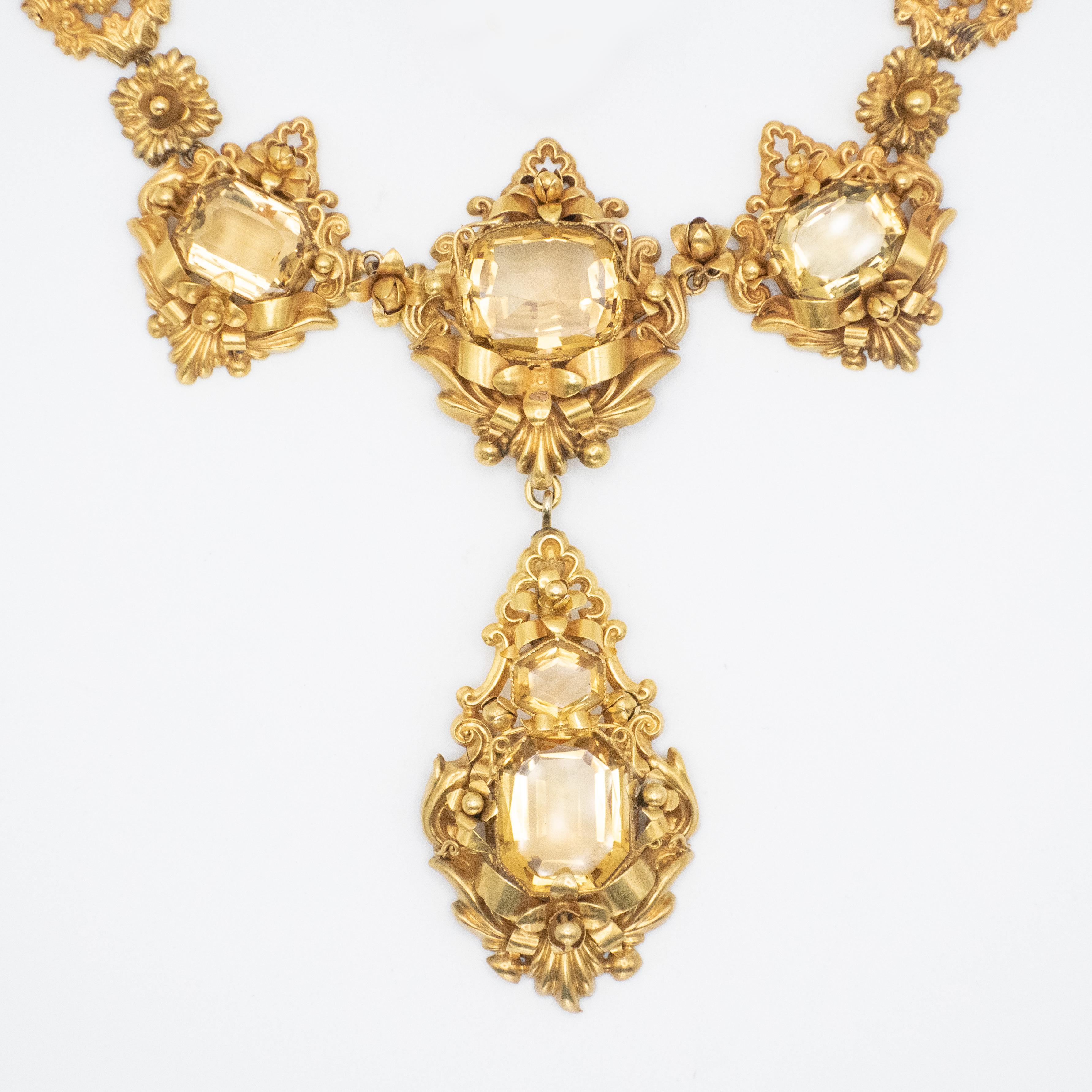 Collana vittoriana in oro giallo 14K con ciondolo a goccia con motivo a fiore e a nastro, orecchini e anelli 

Peso approssimativo:
Collana - 88,7 grammi
Orecchini - 8,0 grammi
Anello - 4,4 grammi

Misure approssimative:
Collana lunga 16