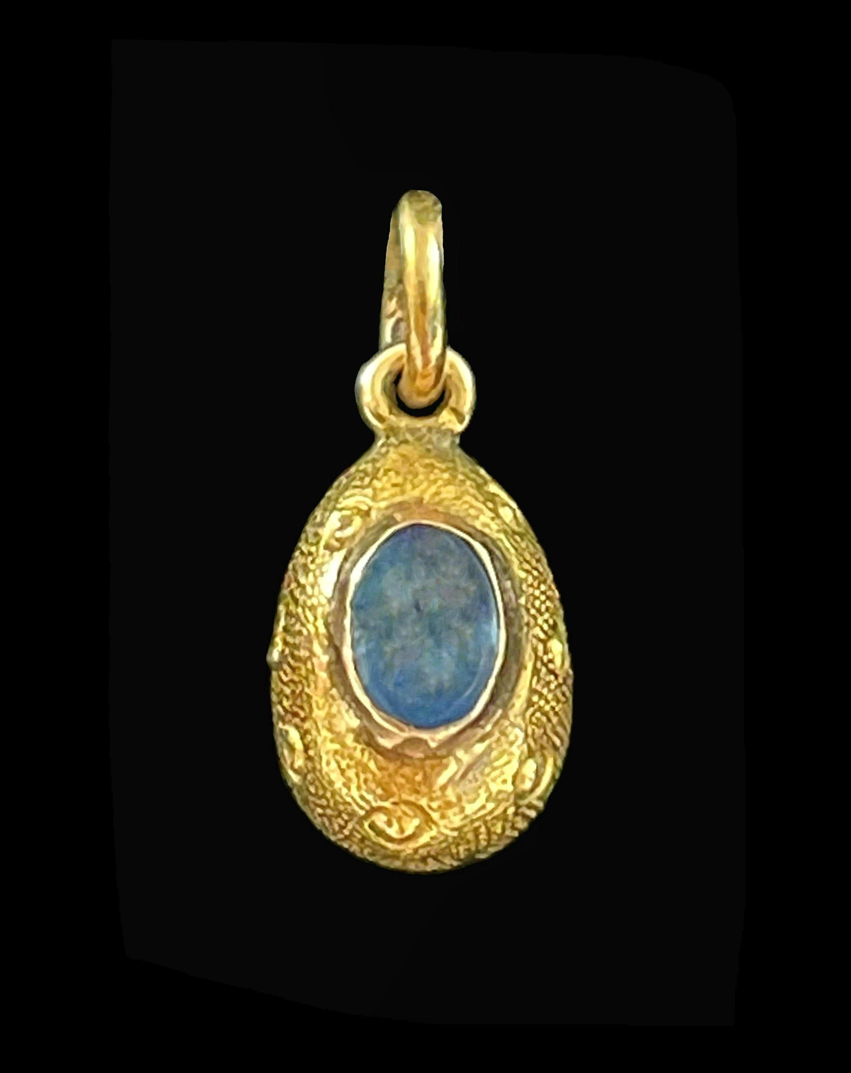Fine antique 14K yellow gold and cornflower blue Sapphire Easter egg charm or pendant - featuring a bezel set cabochon cut Sapphire (approx. 0.57 Total Carat Weight - 3.5 mm. Wide x 5.0 mm. Long x 3.0 mm. Deep) - the gold body of the egg delicately