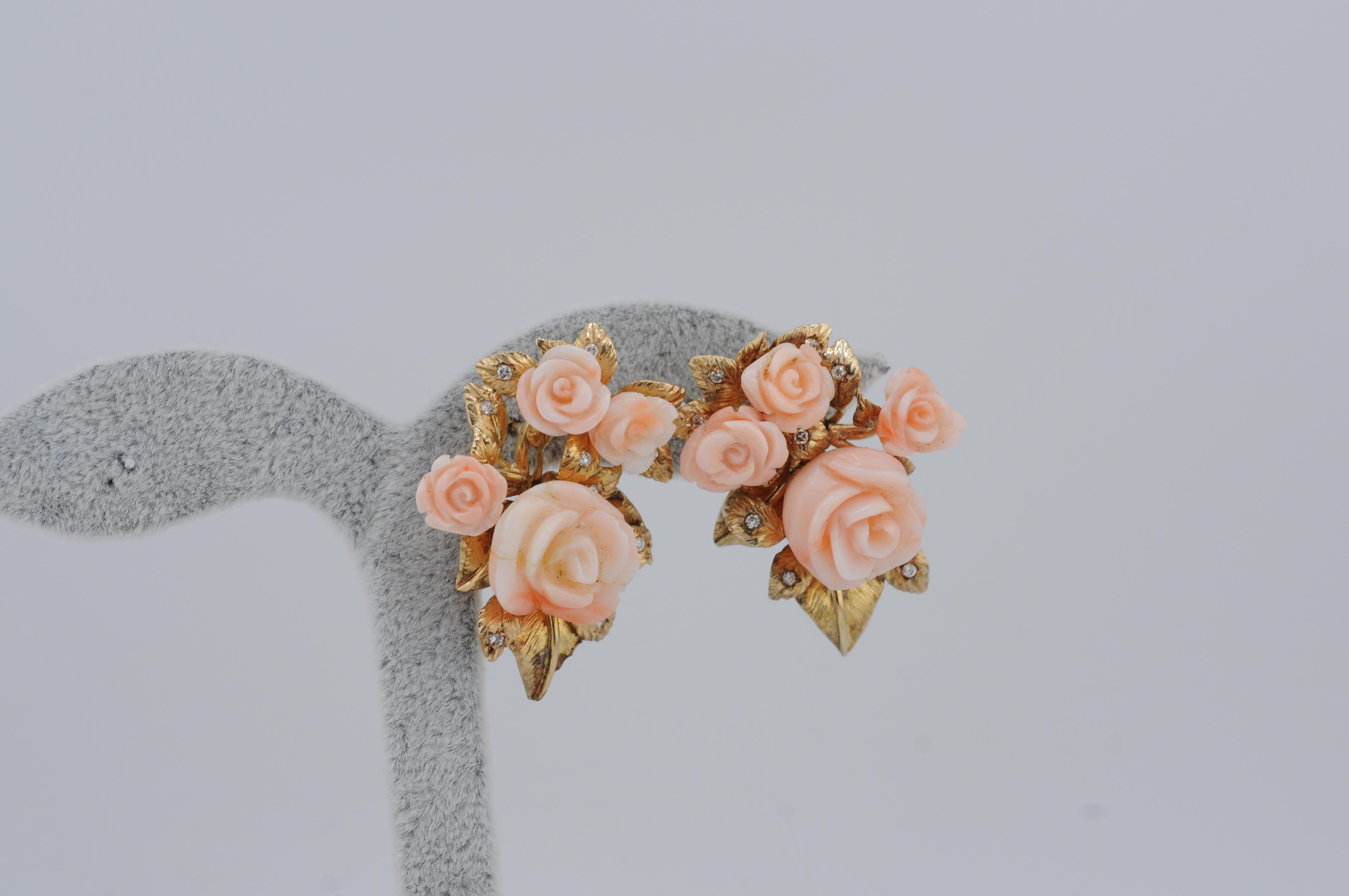 Delicate antique stud earrings crafted in 14 karat yellow gold, featuring finely carved rose blossoms in natural angel skin coral. The soft blush hue and floral detailing reflect the refined artistry of early 20th-century craftsmanship. A graceful,