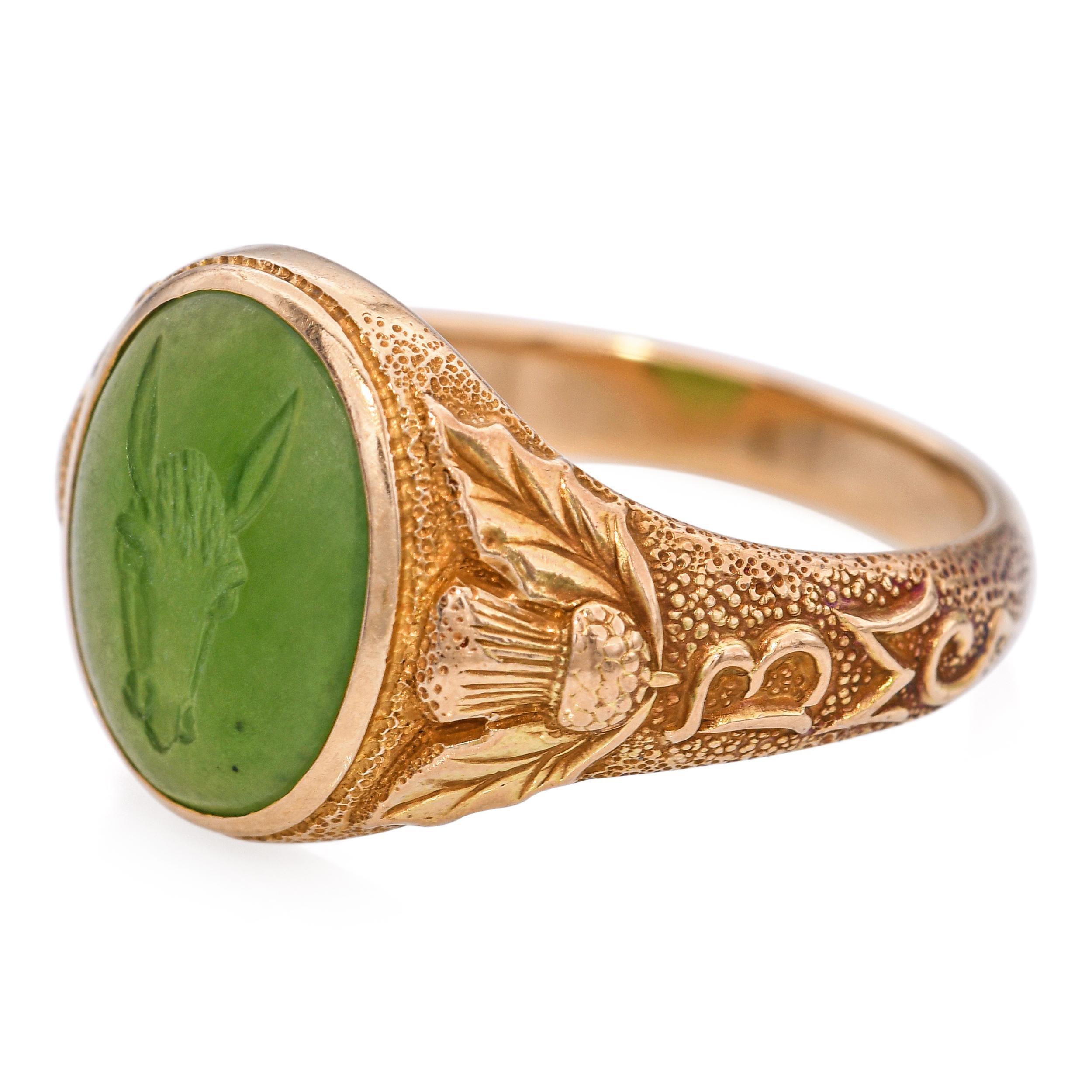 This exquisite antique piece is crafted in 14k gold and showcases a finely carved nephrite jade intaglio depicting a horse. The detailed engraving captures the strength and grace of the animal, reflecting exceptional artistry. The rich green jade