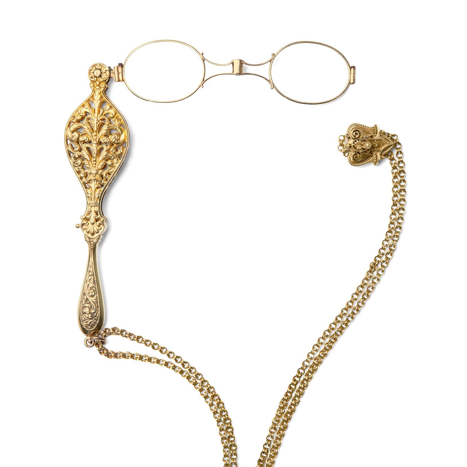 Collectable and beautiful, this antique Victorian 14k lorgnette is crafted with pierced, ornate scrolling designs, suspended from a handmade round link long chain, with a slide set with a half-pearl. In phenomenal condition, the necklace weighs 57