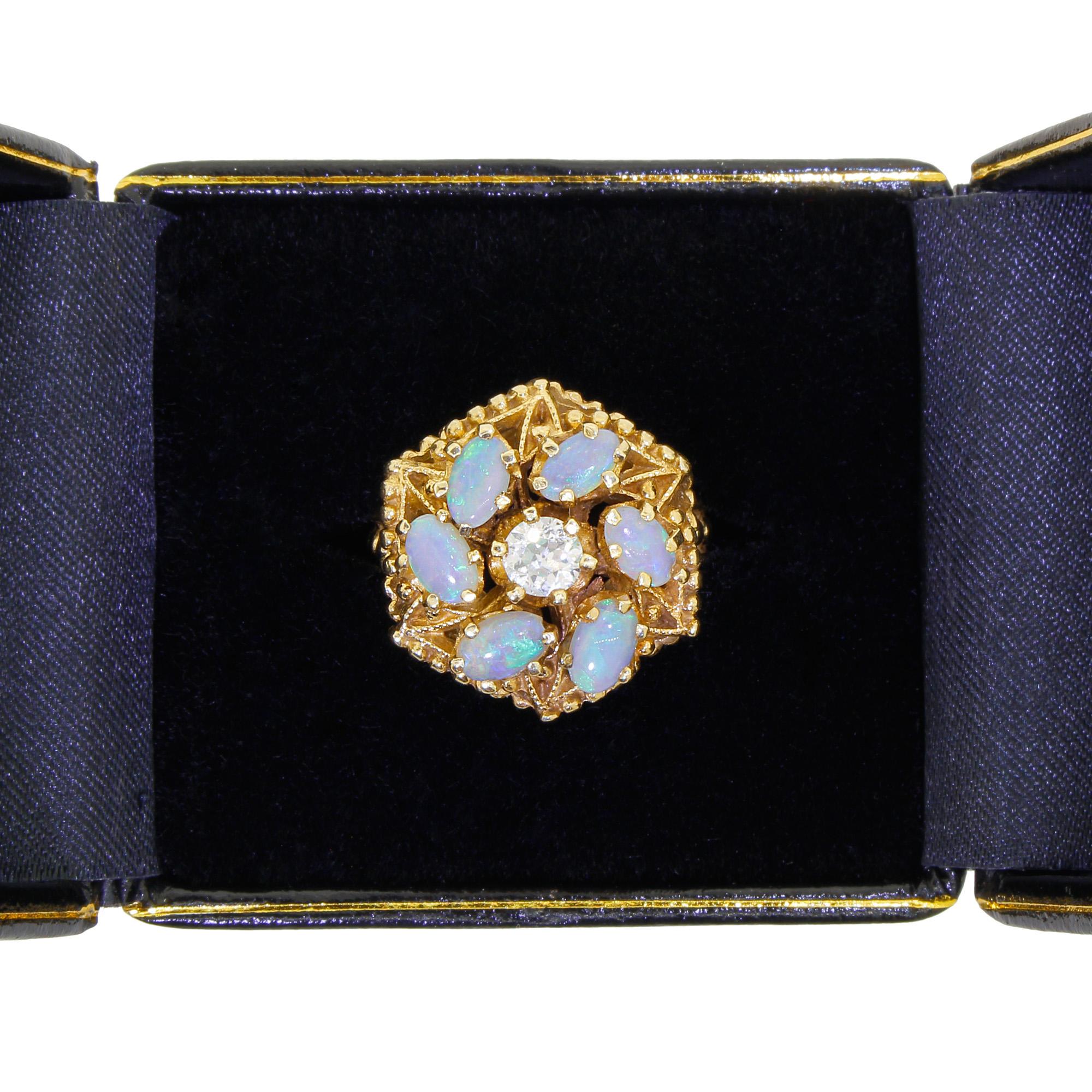 This stunning Victorian style 14K yellow gold ring features six antique Australian Opals set in a pinwheel formation with a diamond at the center.
The stones show beautiful natural colors of peacock green, blues - violets, and warm undertones in the
