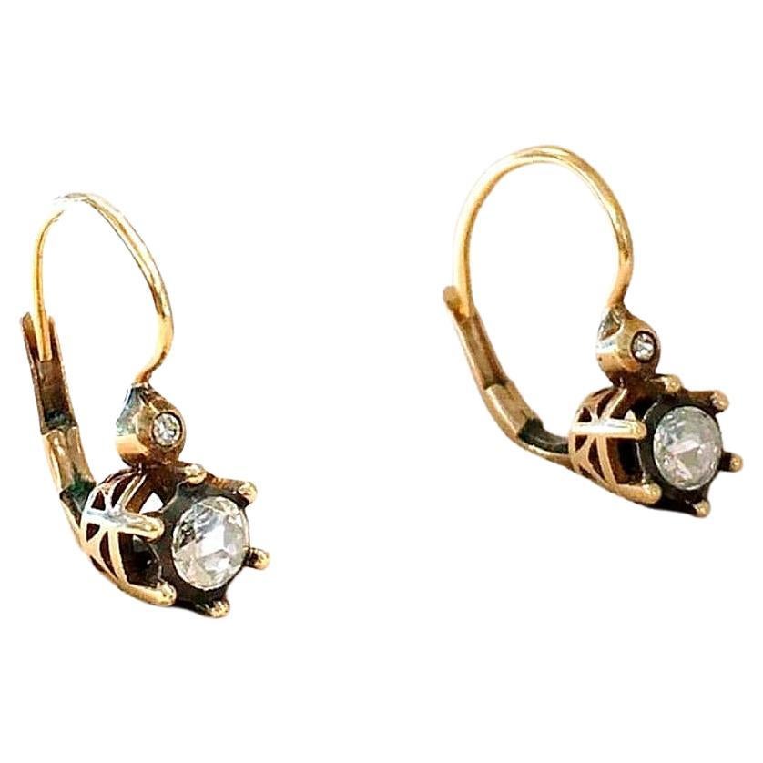 Antique 14k gold dangling earrings centered with rose cut diamond with estimate weight of 0.70ct and 4.3mm diameter each stone in detailed open work style prongs 