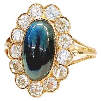 Antique 14k gold ring centered with large cabouchon mid night blue sapphire colour with a diameter of 13mm×8mm in oval cut  flanked with old mine cut diamonds estimate weight 1.50 carats 