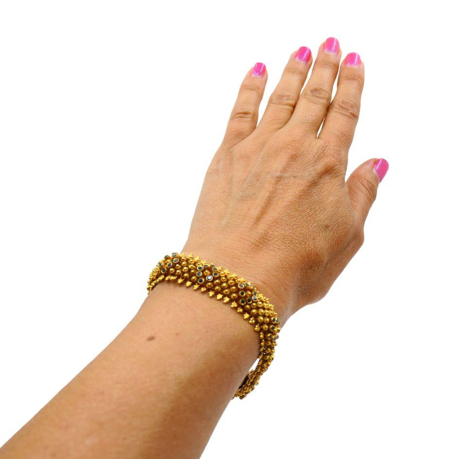Un bracelet antique exquis en or jaune 14k, avec des saphirs.
Le motif floral de ce bracelet a été méticuleusement créé à l'aide de différents orfèvres.
technique. La pièce présente de délicats détails en or granulé. De minuscules perles dorées