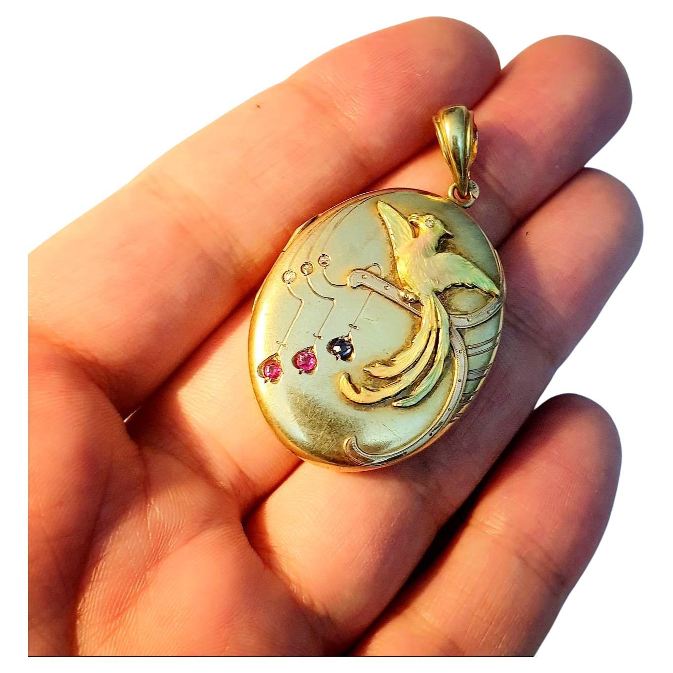 Antique russian locket pendant with an colourful enamel bird on front decorted with natural blue sapphire and rubies in 14k gold setting with total weight of 9.3 grams and 5cm lenght the pendant was made in moscow 1904/1907.c imperial russian era