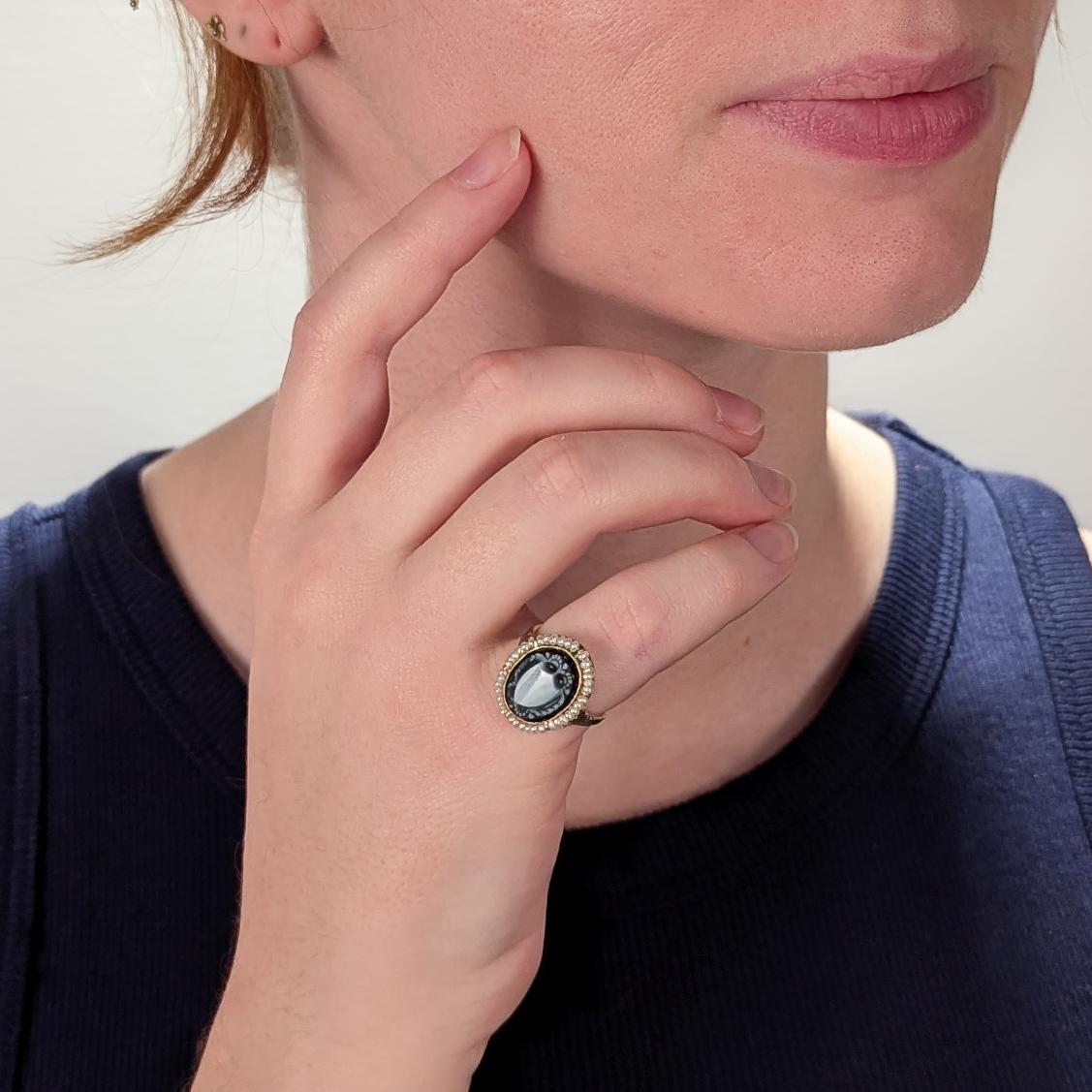 A fine vintage gold, sardonyx, and seed pearl ring.

In 14 karat yellow gold. 

With a carved sardonyx cameo shield device surrounded by a halo of seed pearls.

Simply a wonderful signet ring!

Date:
Early 20th Century

Overall Condition:
It is in