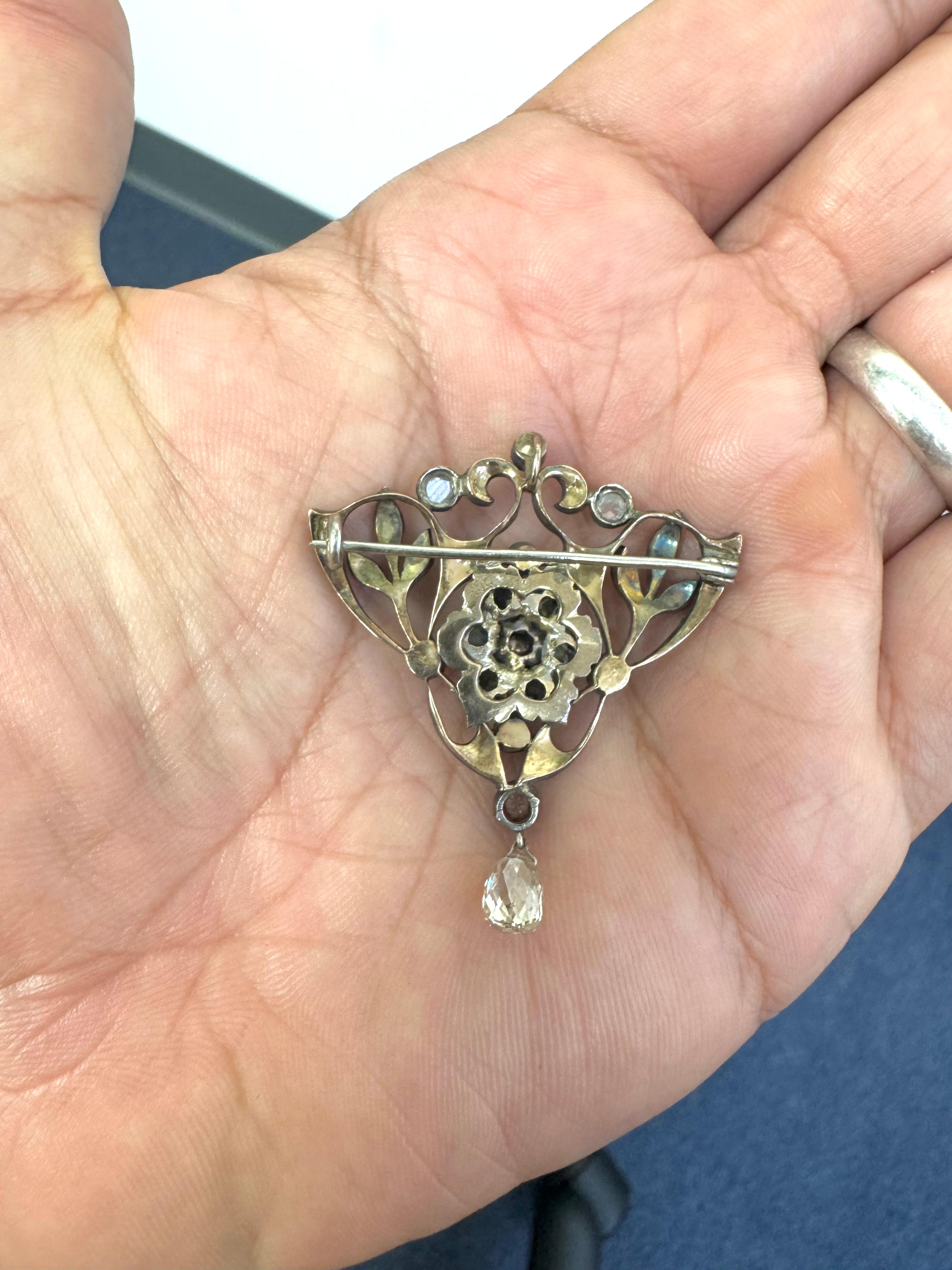 Broche ancienne de la fin du XIXe siècle magnifiquement conservée, réalisée en or jaune 14 carats avec des superpositions d'argent dans le style traditionnel de l'époque. Le motif floral ajouré est centré sur une grappe de diamants taillés dans des