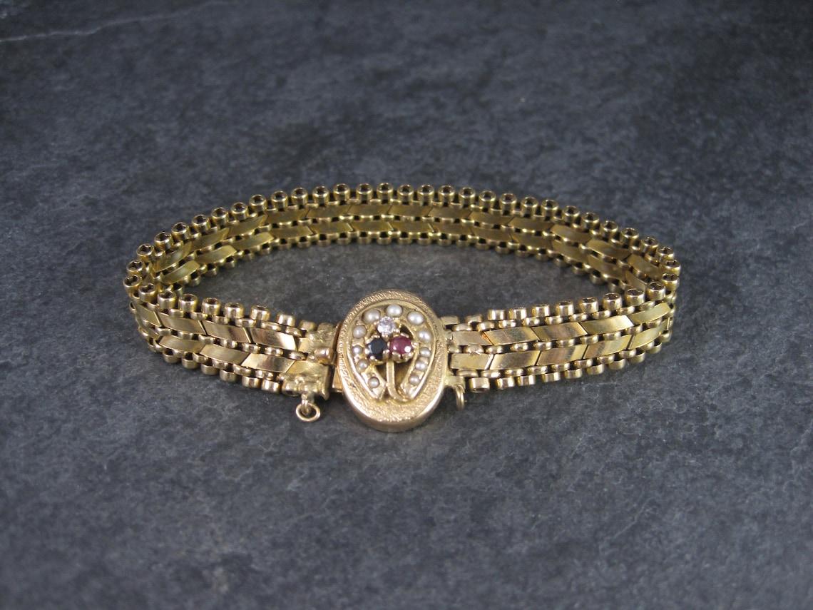 This gorgeous vintage bracelet is solid 14k yellow gold.

It features genuine seed pearls, a natural sapphire, a natural ruby and genuine diamond.

The sapphire and ruby are each 3mm. The diamond is 2mm.
The horseshoe clasp measures 9/16 by 3/4
