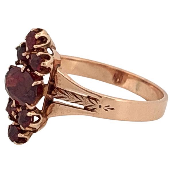 Questo squisito anello antico è splendidamente realizzato in oro rosa 14k e mostra un'eleganza senza tempo e una raffinata lavorazione artigianale. Il cuore di questo gioiello è costituito da un granato ovale da 0,65 carati, che emana una profonda e