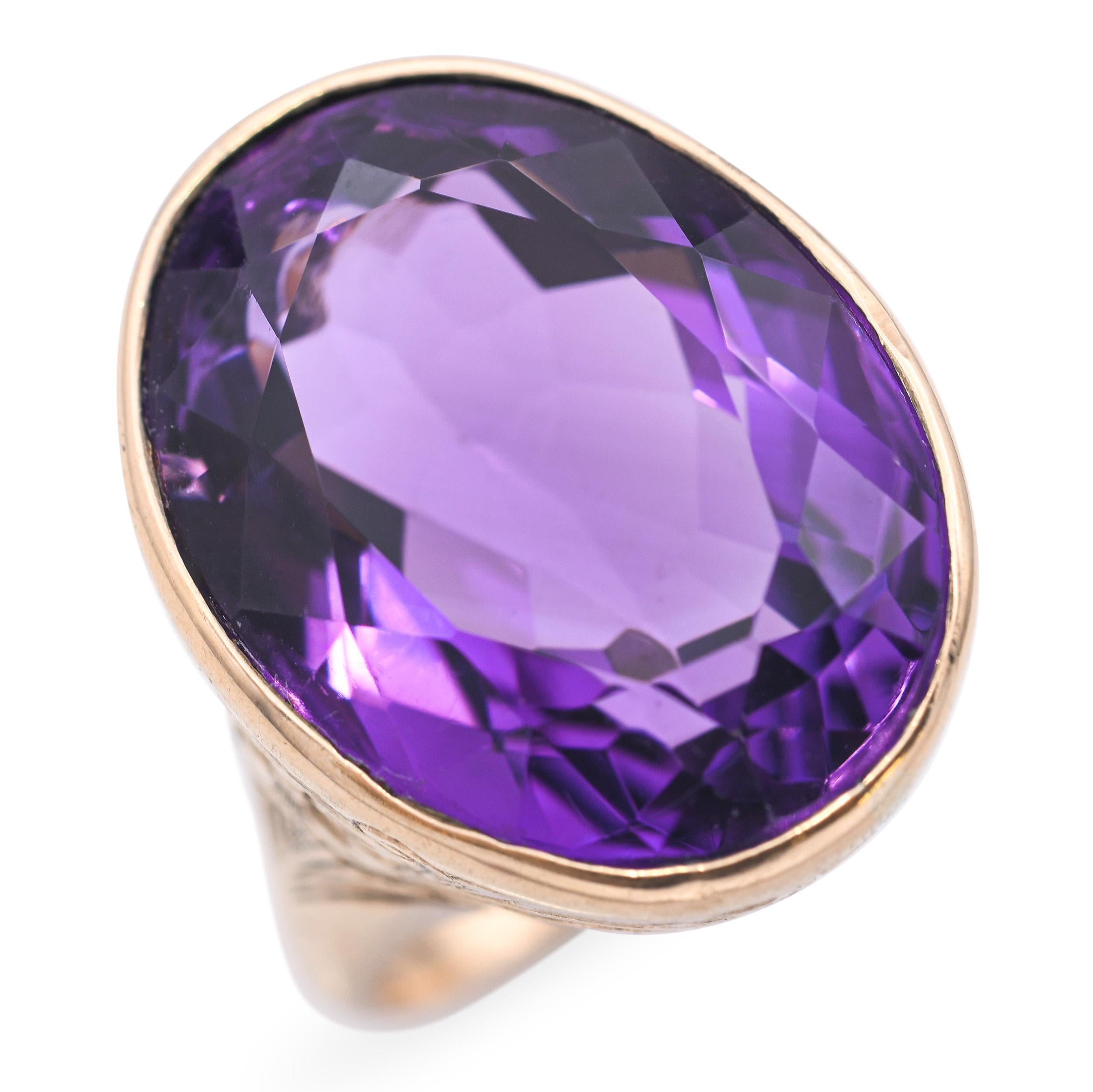 Cette exquise bague ancienne est réalisée en or rose 14 carats et met en valeur une magnifique améthyste de 17 carats. La grande pierre précieuse aux teintes riches est complétée par des gravures florales complexes le long du bracelet, ajoutant une