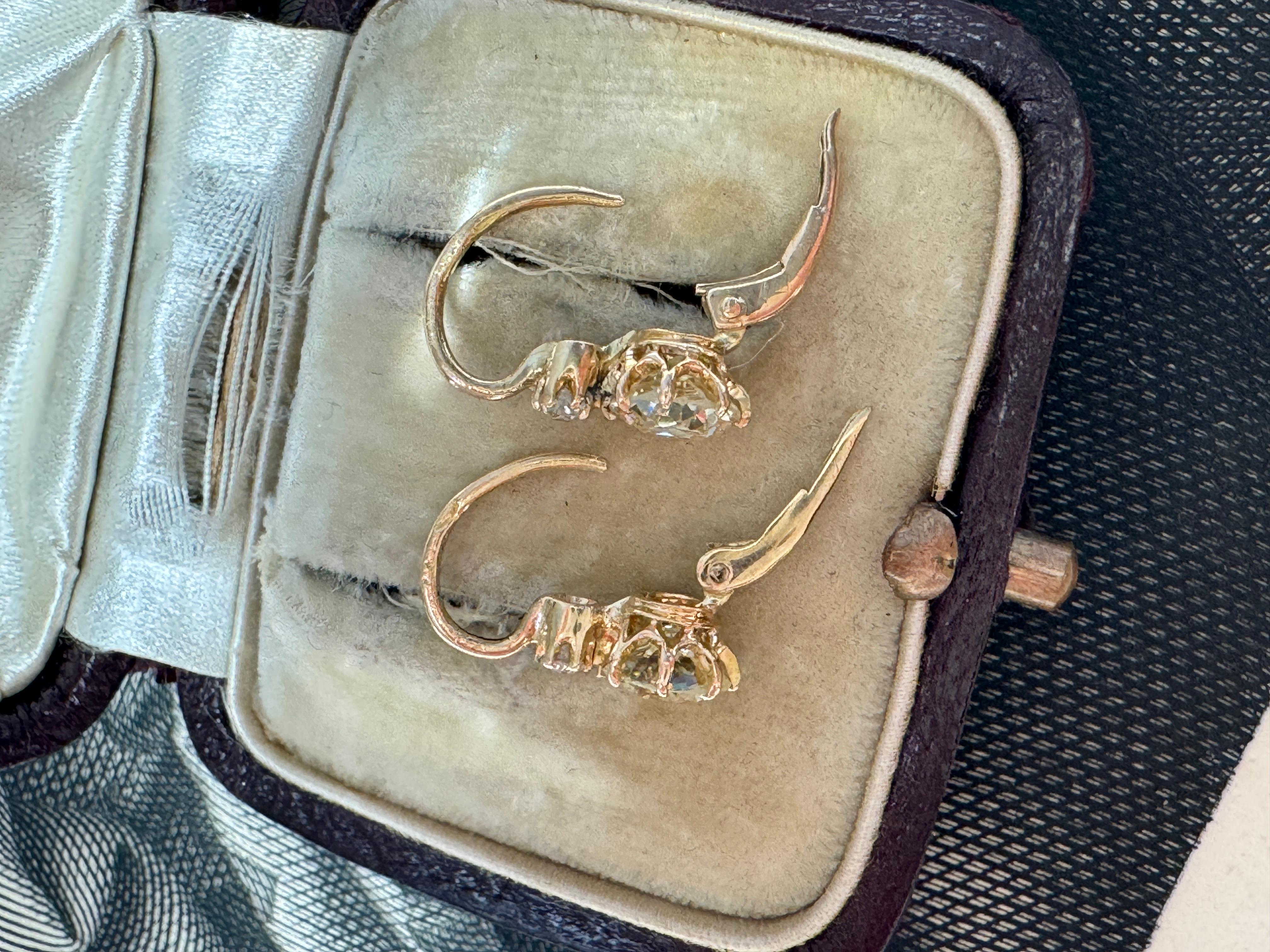 Dating to the turn of the 20th century, these antique Austro-Hungarian earrings showcase a dazzling duo of old European-cut diamonds, each weighing approximately 0.80 carats, crowned by a pair of sparkling old-cut diamond. Crafted in 14k gold,