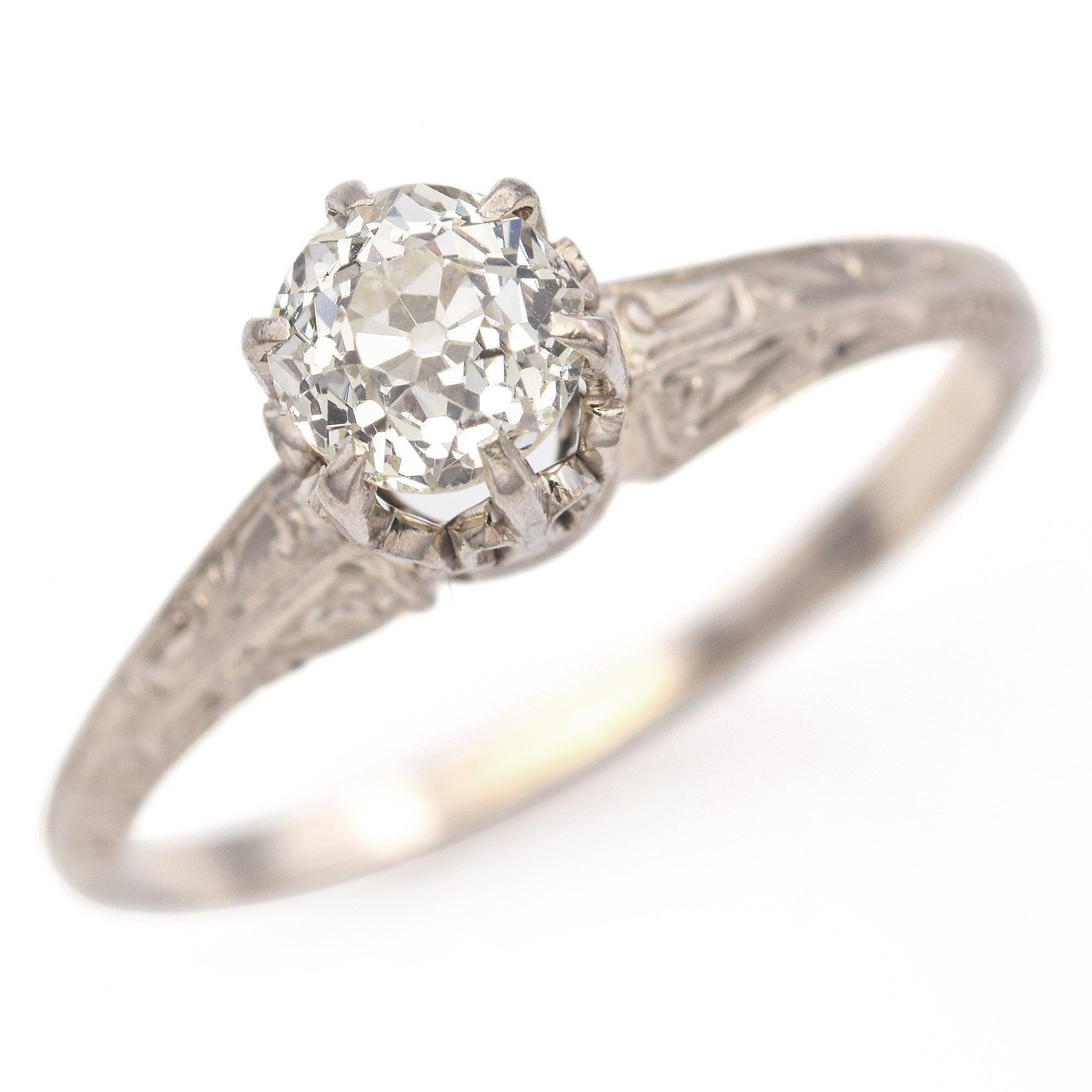 Cette bague à diamant antique est finement fabriquée en or blanc 14 carats avec un sertissage à haute couronne caractéristique qui met en valeur son charme vintage. En son centre repose un diamant de taille européenne ancienne de 0,67 carat, connu