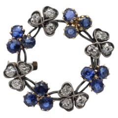 Broche antiguo de oro blanco de 14 quilates con 12 diamantes talla brillante y 12 zafiros