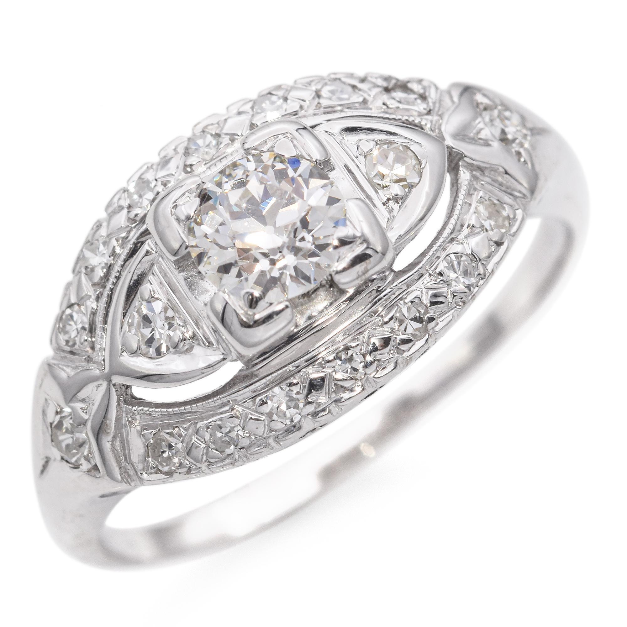 This exquisite ring showcases a central round diamond, securely set in a square bezel. Flanking the center stone are two smaller diamonds, each nestled within a marquise-shaped frame. The band is adorned with intricate latticework, embellished with