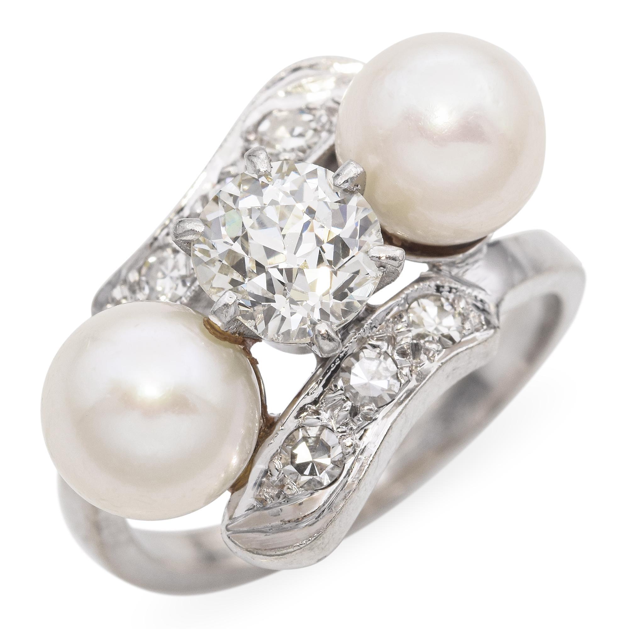Cette exquise bague ancienne en or blanc 14 carats, ornée de perles et de diamants, capture l'élégance intemporelle d'une époque révolue. Une perle naturelle lustrée et de grande qualité trône au centre, entourée de diamants étincelants qui