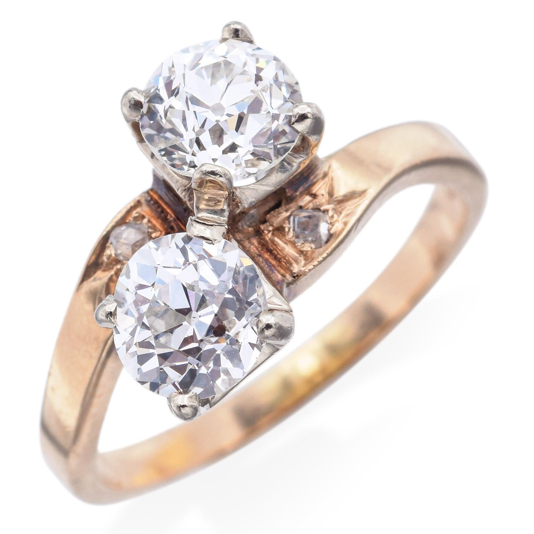 Un grazioso anello bypass antico realizzato in oro giallo 14K, con due scintillanti diamanti taglio vecchia Europa al centro. Il design del bypass si curva elegantemente intorno al dito, simboleggiando unità e armonia, mentre le piccole pietre