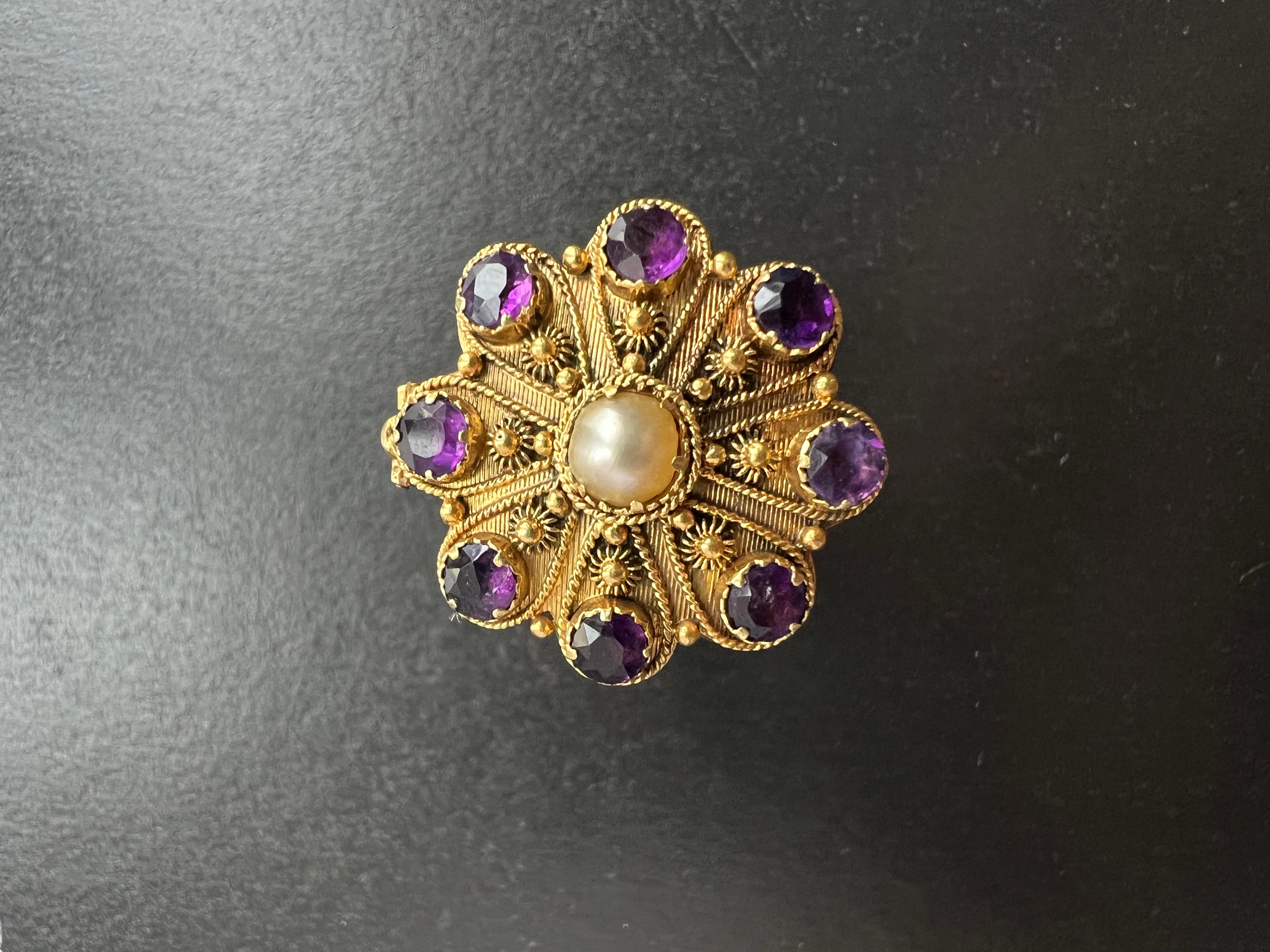 For sale a magnificent 14K gold secret box ring (also called poison ring). The ring features a rare flower box container on the ring’s head, which is decorated with 8 amethyst stones on the petals. The gem shows a vibrant purple color, contrasting